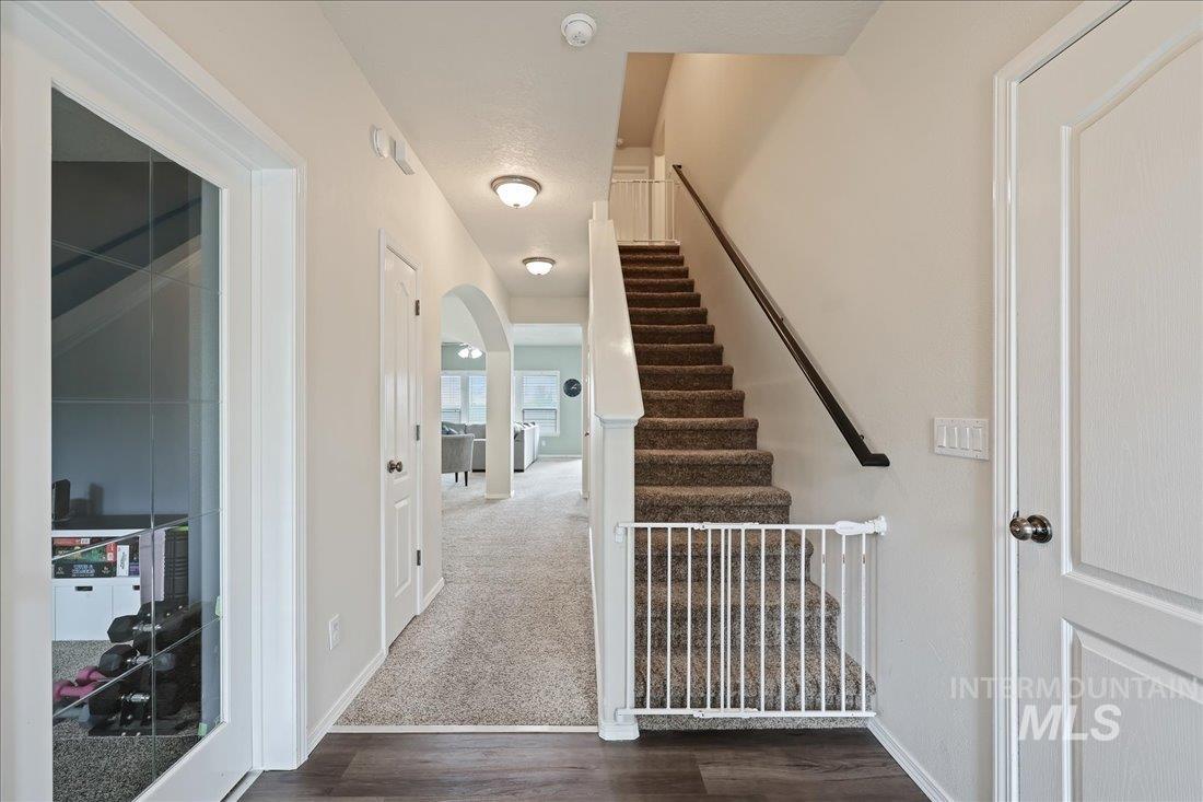 Stairway featuring wood finished floors, arched walkways, and carpet floors