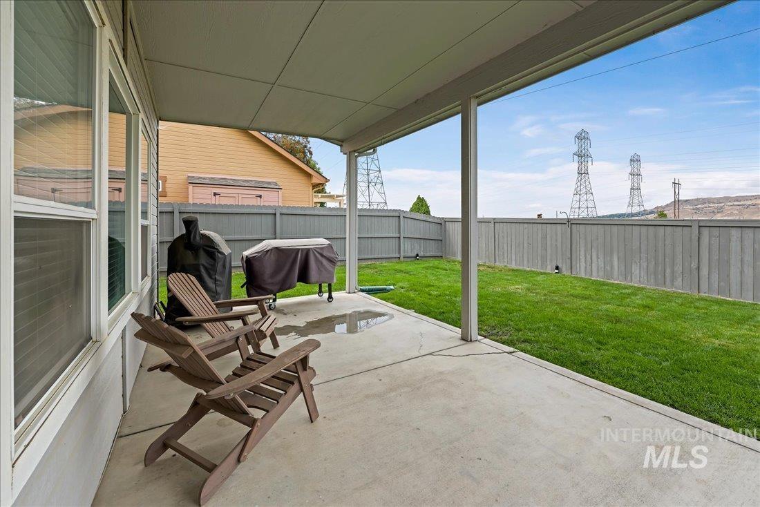 Fenced backyard featuring a patio area and grilling area