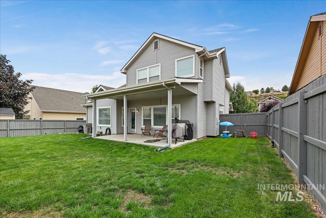 Rear view of house featuring a fenced backyard and a patio area