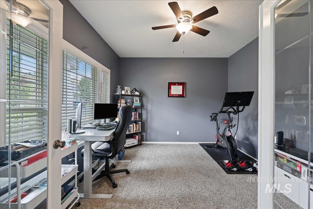 Office with a ceiling fan, carpet, and a textured ceiling