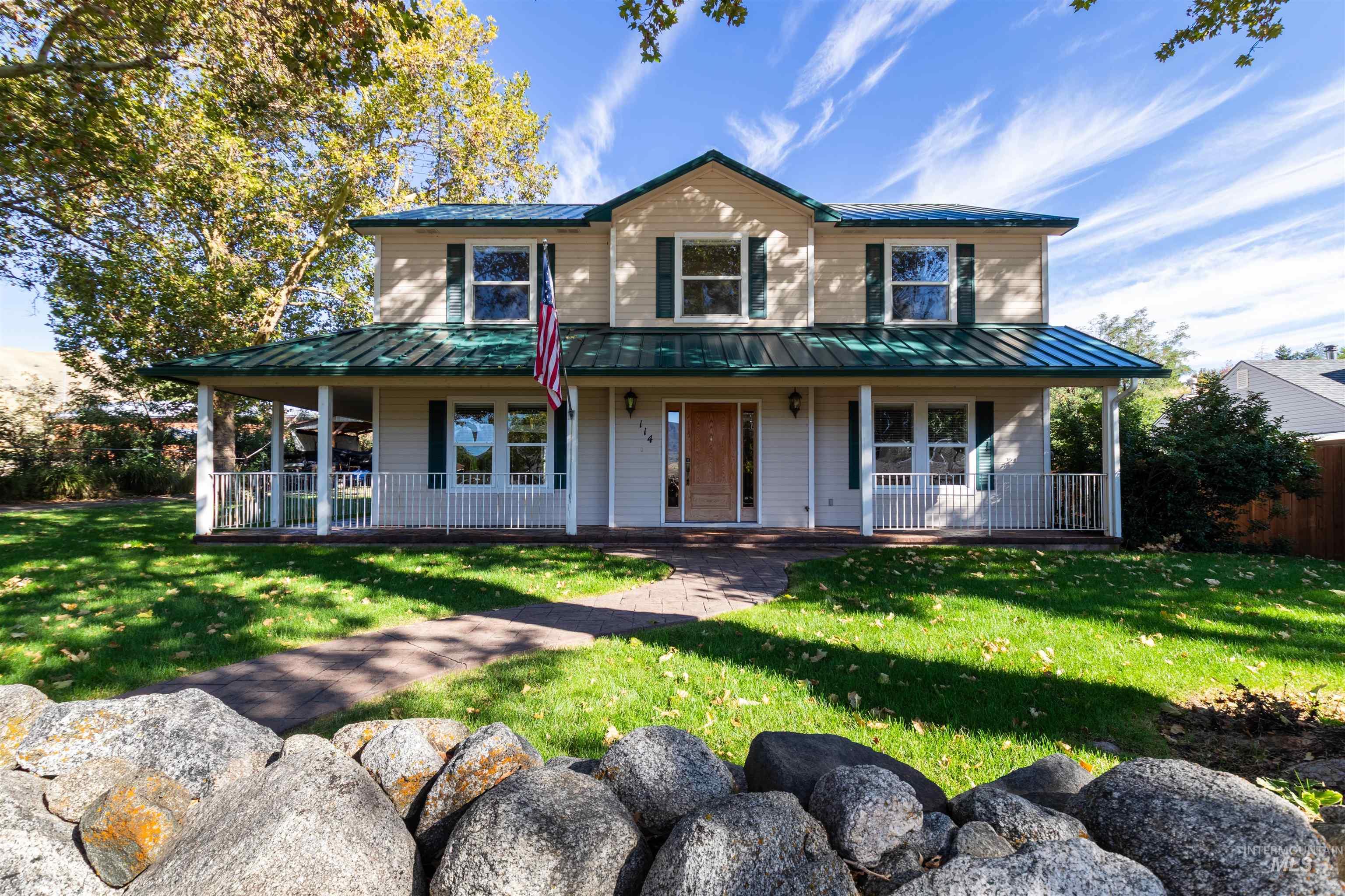 Farmhouse featuring, a metal roof, covered porch, a front lawn
