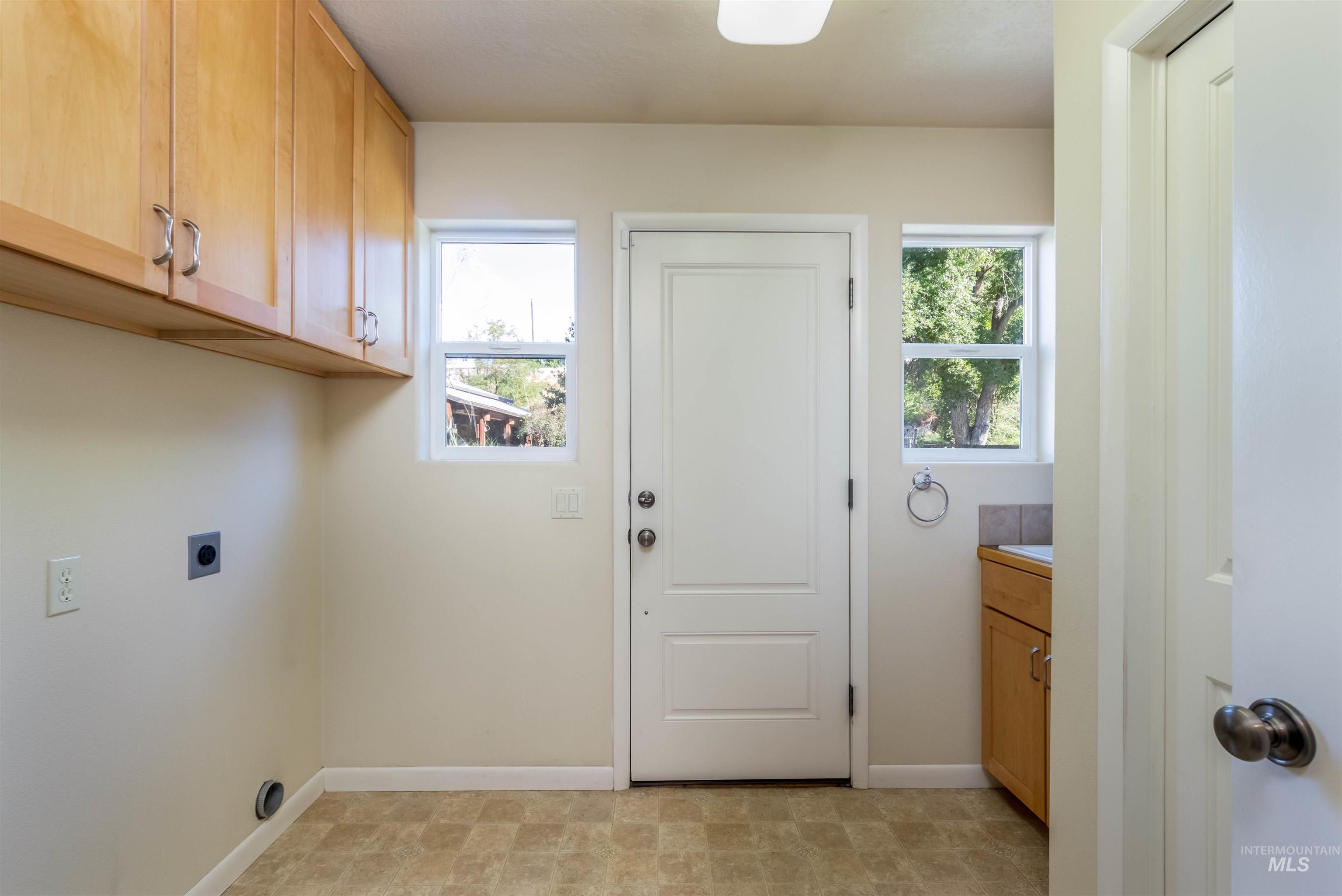 Laundry area with cabinet space, healthy amount of natural light, and electric dryer hookup, water heater & electric furnace