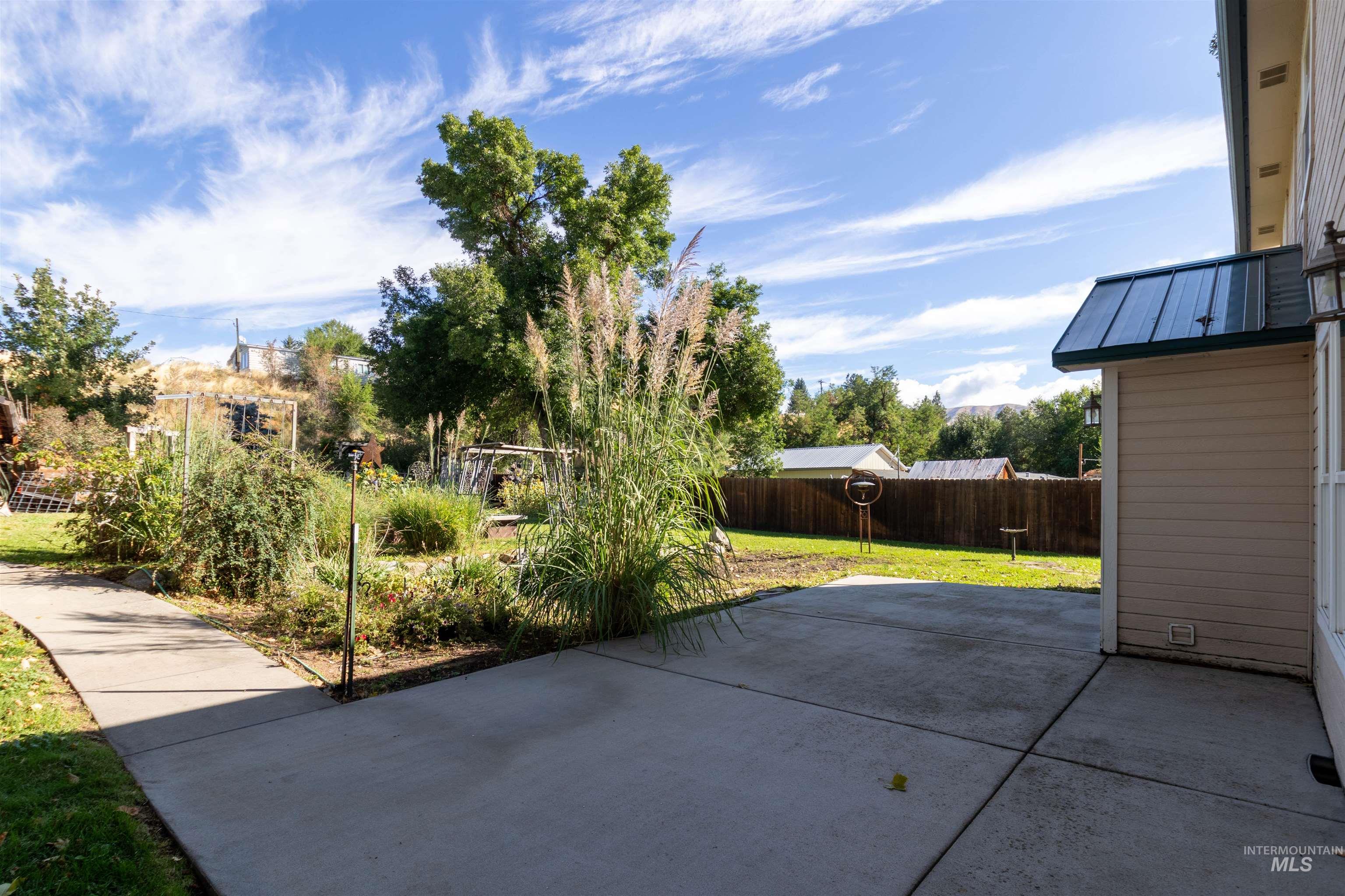 Partially fenced backyard featuring a patio area