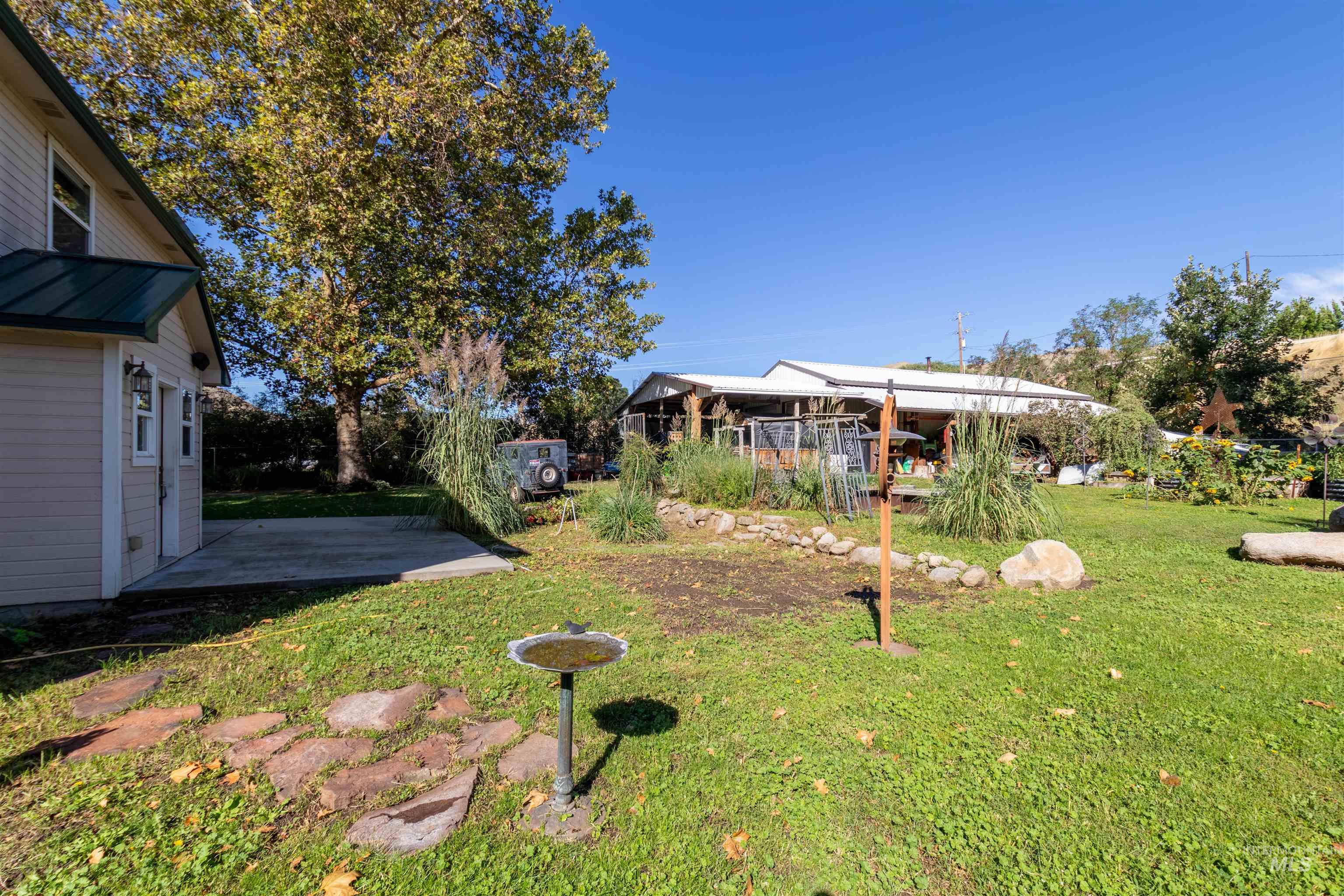 View of grassy yard featuring a patio