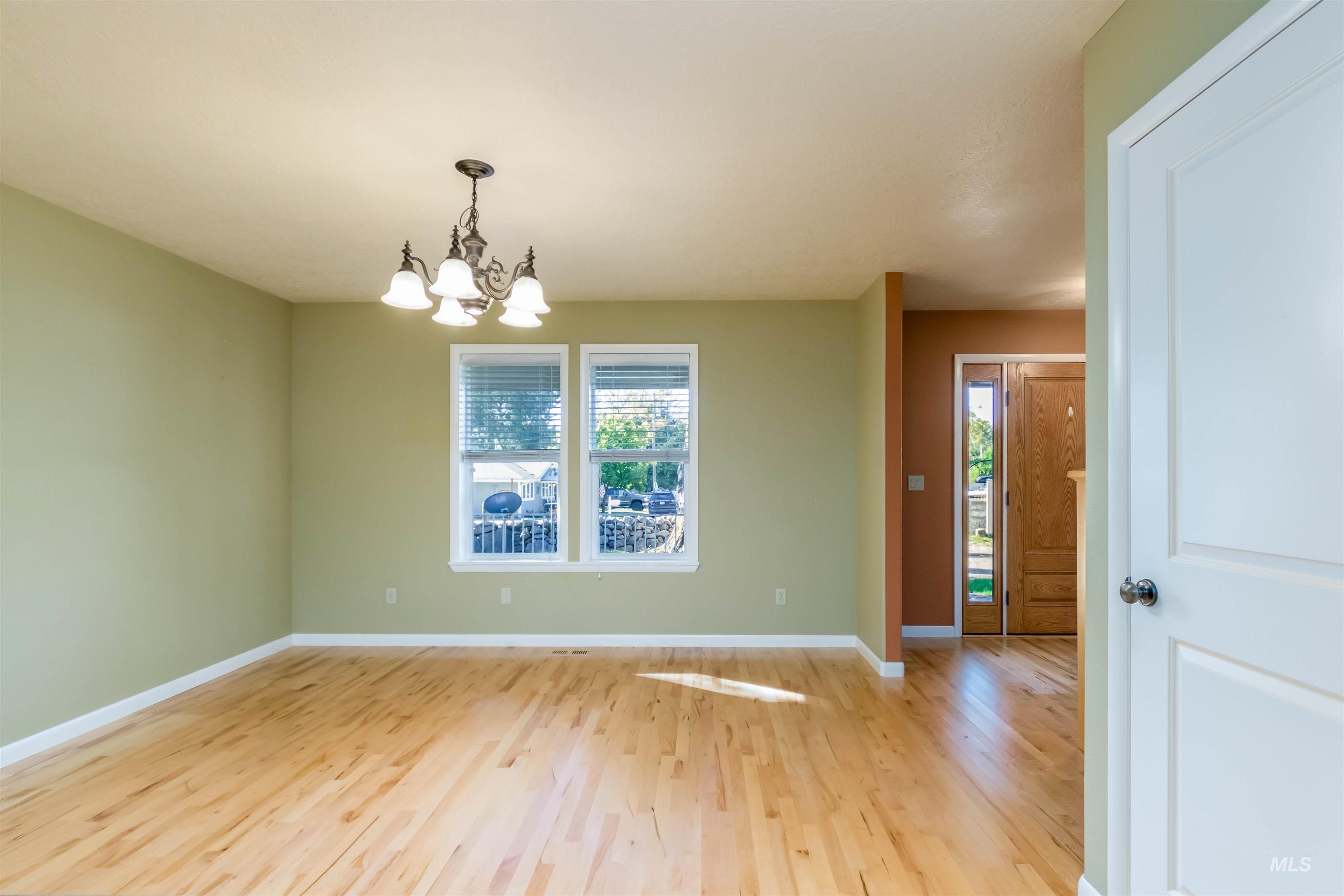 large dining area with a chandelier and maple hardwood flooring