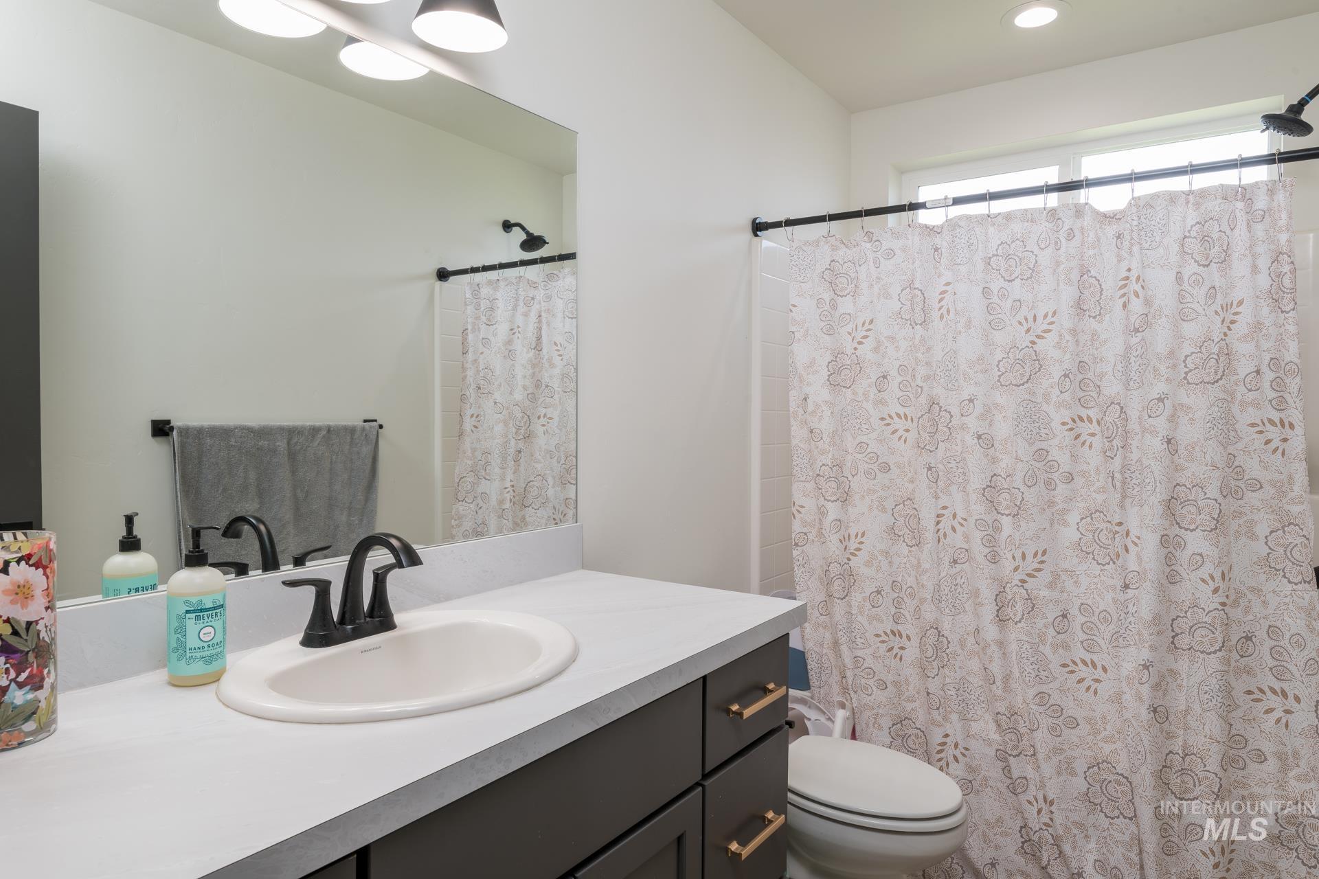 Bathroom featuring vanity and curtained shower