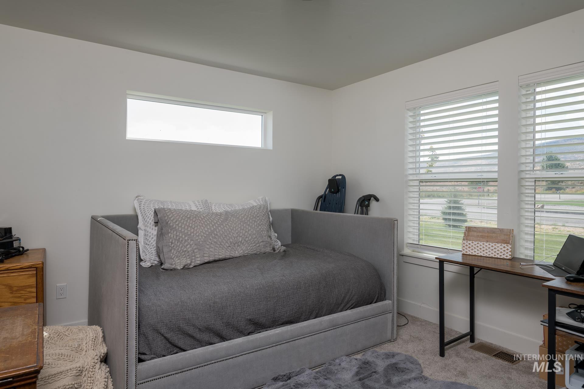 Bedroom featuring carpet and baseboards