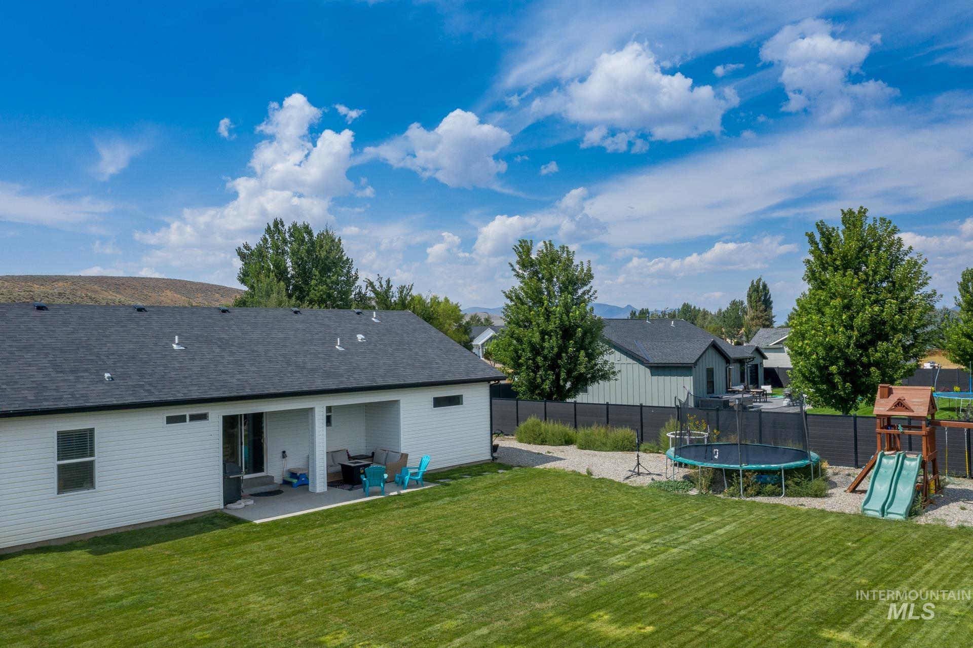 View of yard with a playground, a patio area, a trampoline, and a residential view
