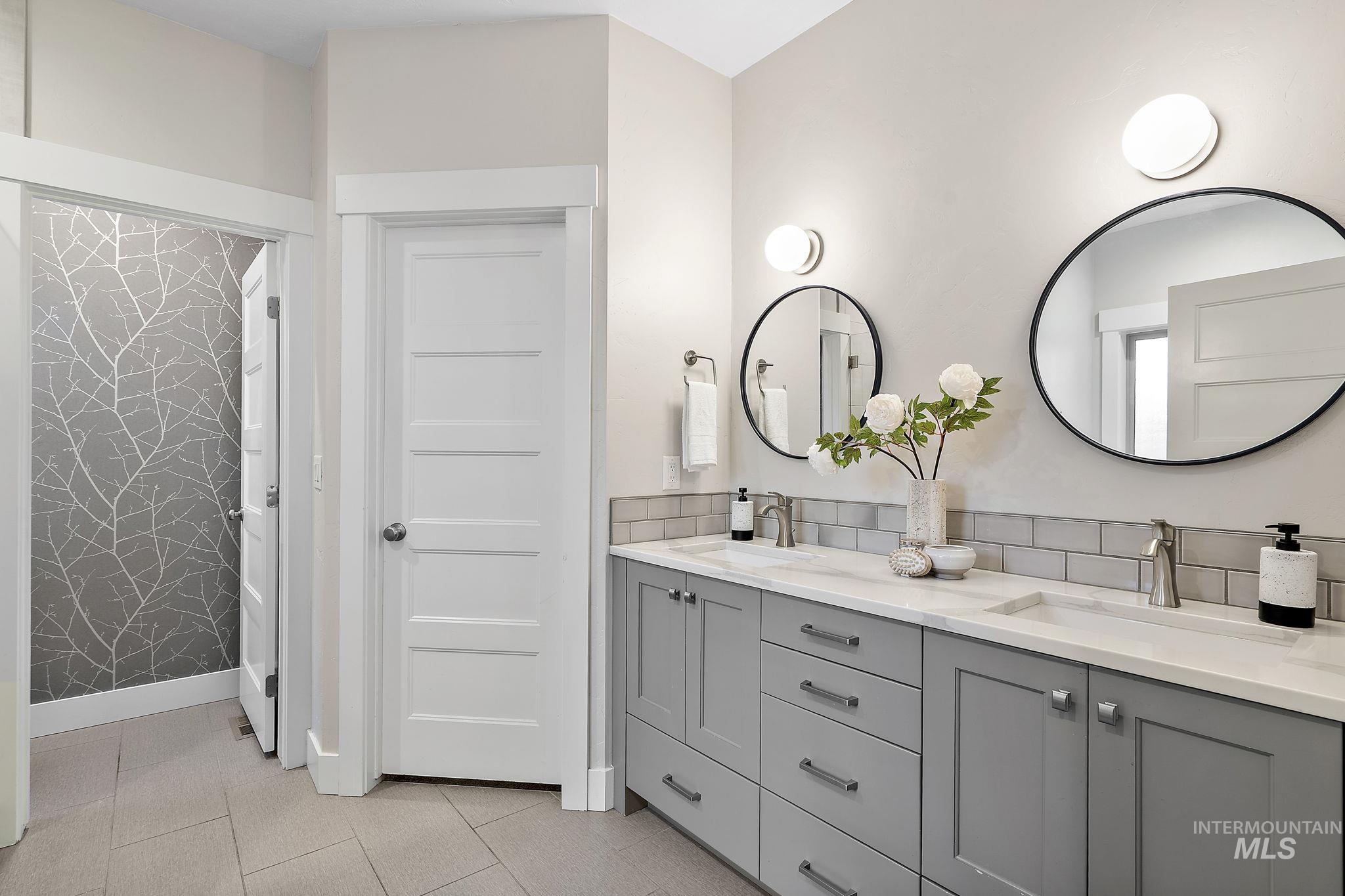 Bathroom with double vanity and light tile patterned flooring