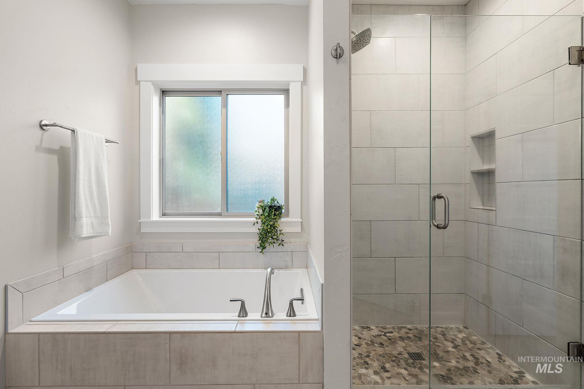Bathroom with a shower stall and a garden tub