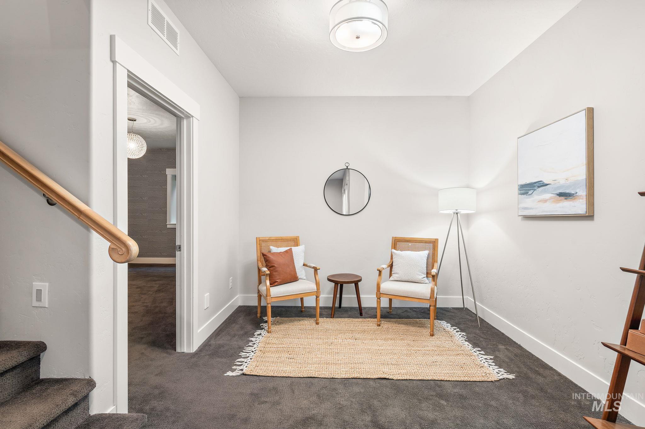 Living area featuring dark colored carpet and stairs