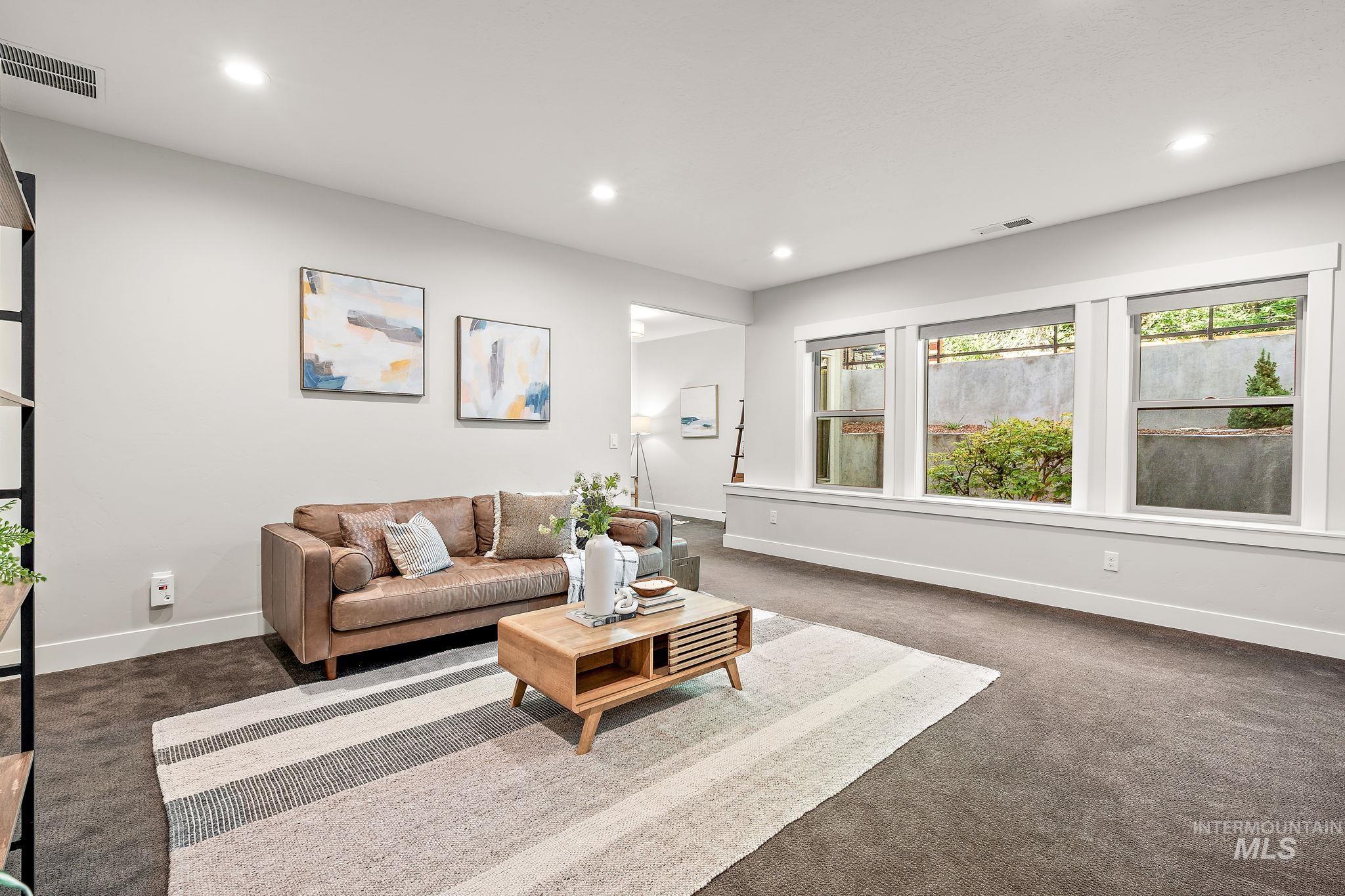Living area with dark carpet and recessed lighting