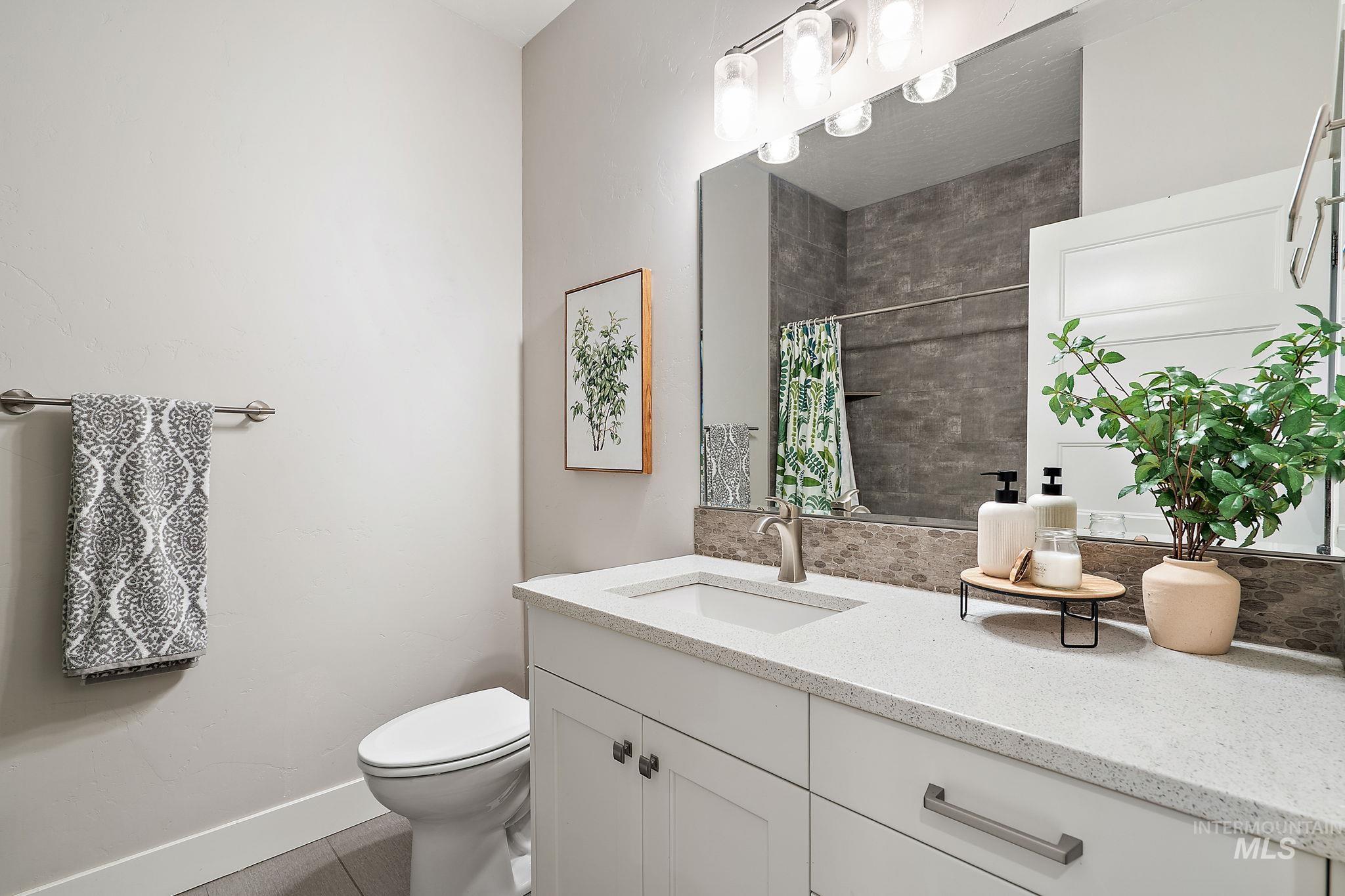 Full bathroom featuring vanity, tiled shower, and tile patterned floors
