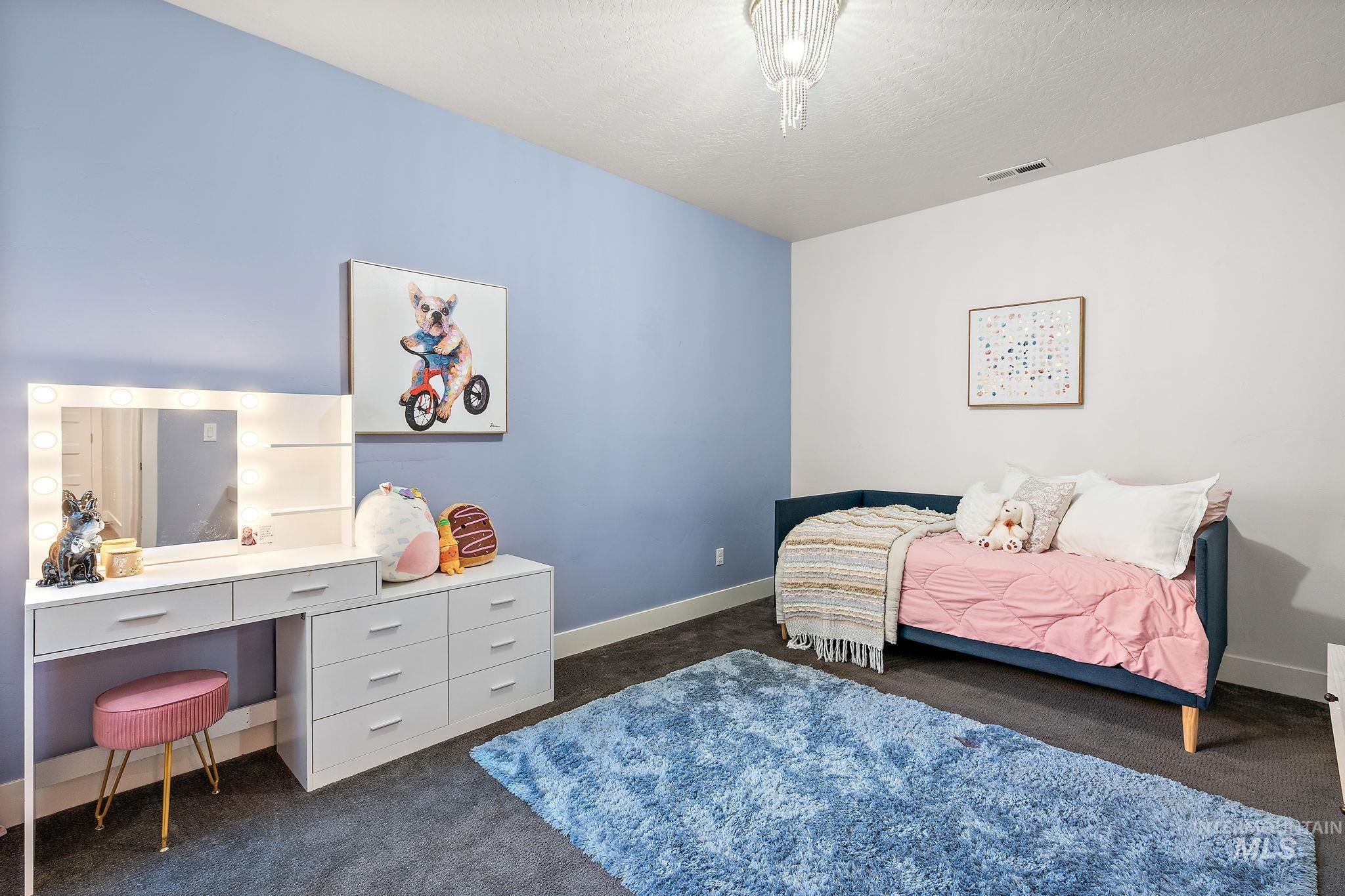 Bedroom with dark carpet and a textured ceiling