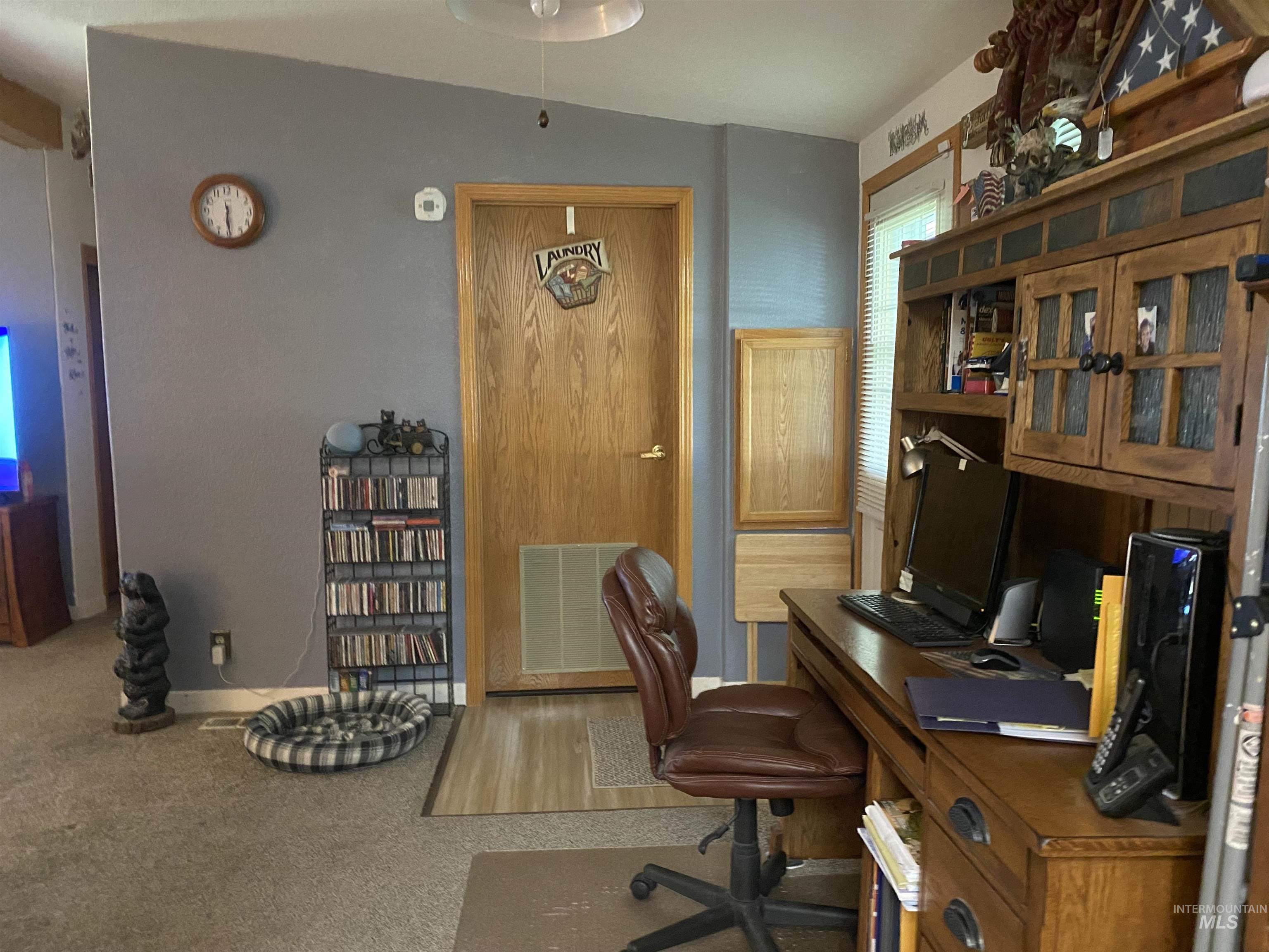 Carpeted home office featuring baseboards