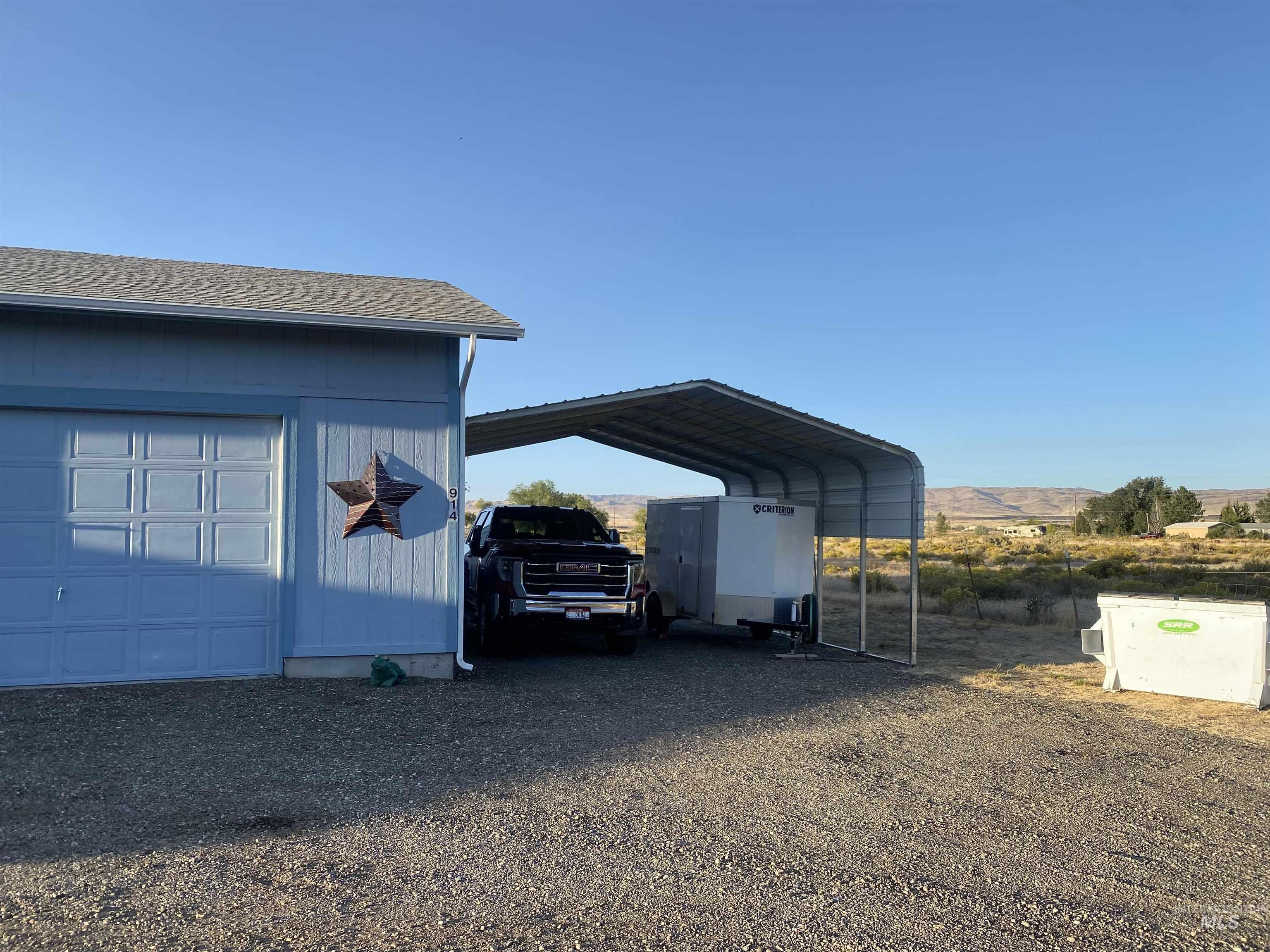 View of parking with driveway and a detached carport