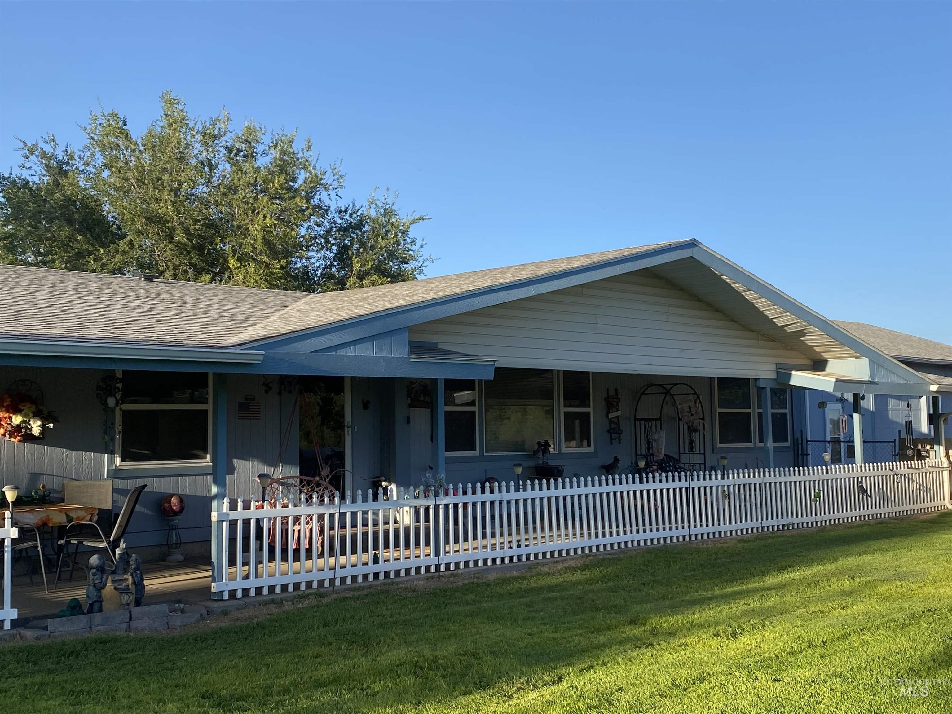 View of front facade with a shingled roof and covered porch