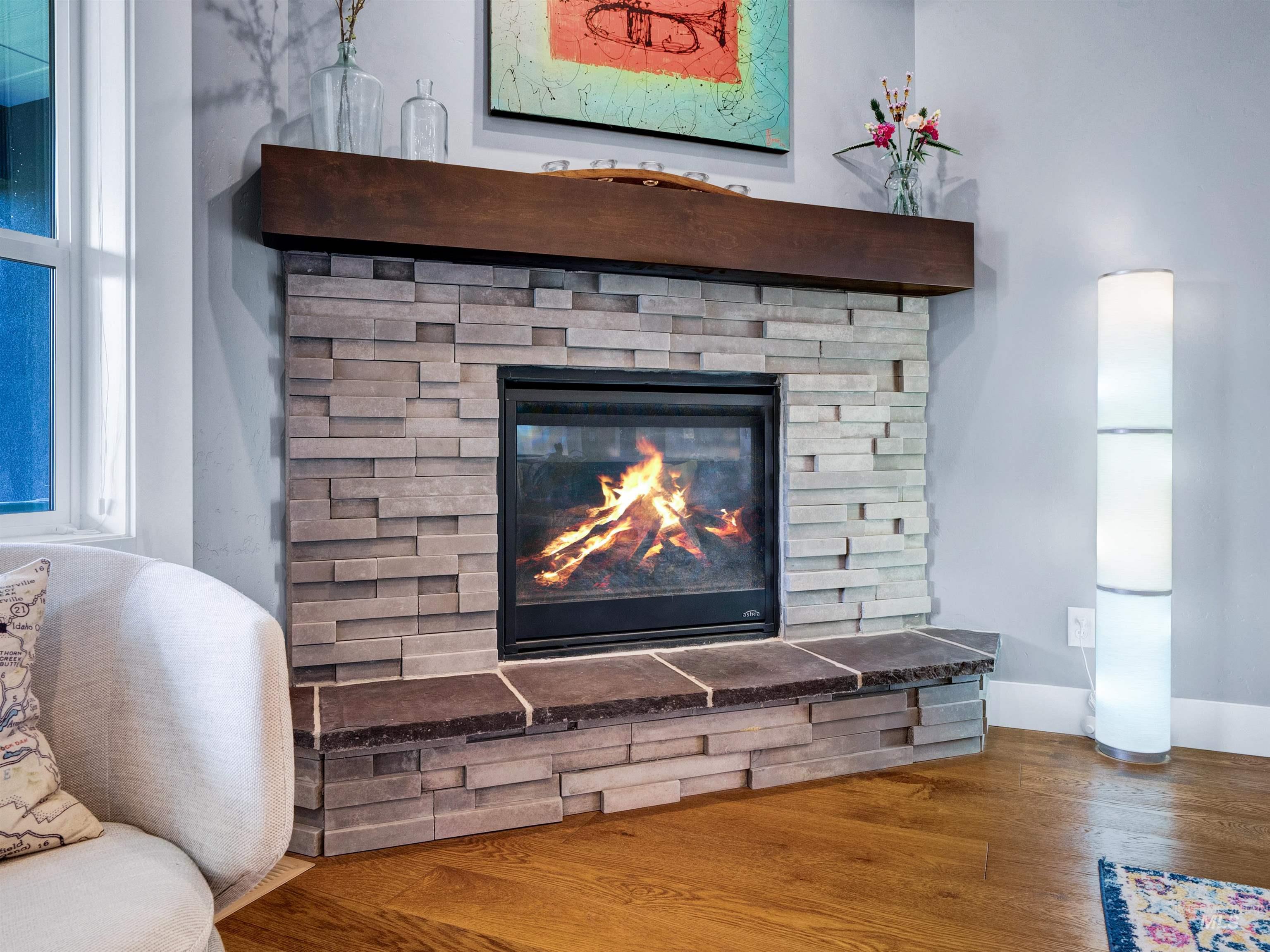 Detailed view of wood finished floors and a stone fireplace
