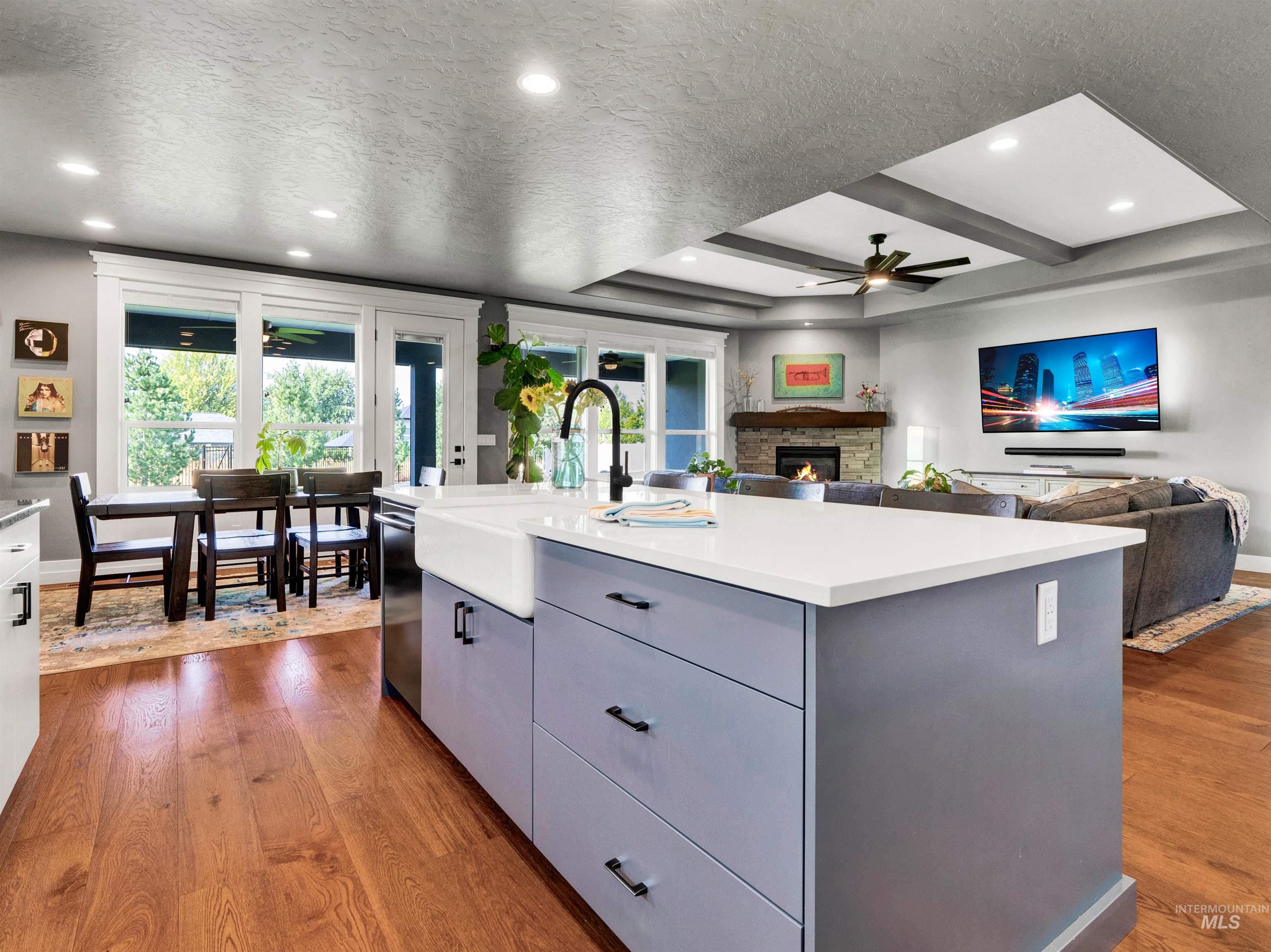 Kitchen featuring a ceiling fan, gray cabinetry, dark wood-style flooring, open floor plan, and a textured ceiling