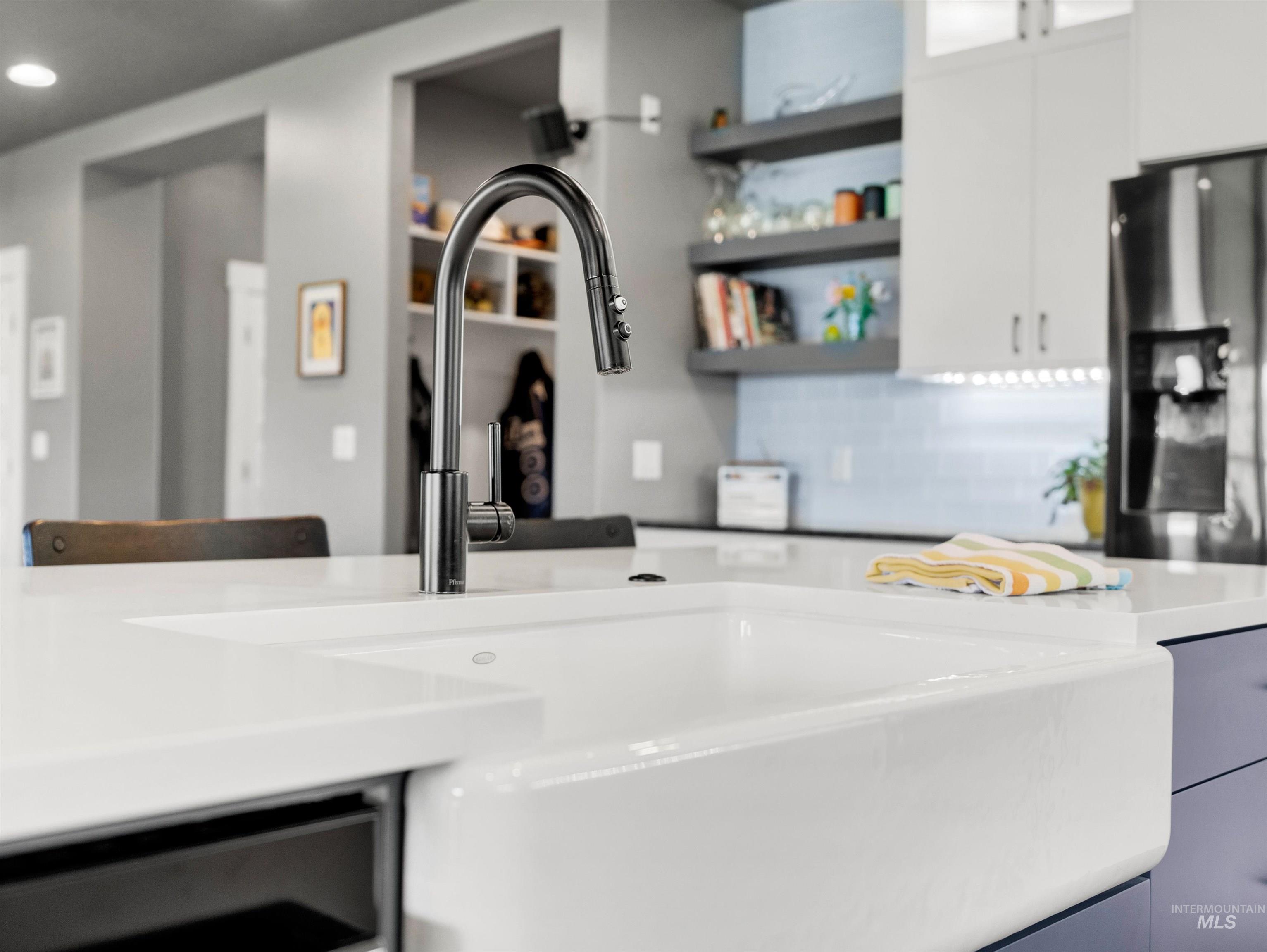 Kitchen with open shelves, tasteful backsplash, stainless steel fridge with ice dispenser, recessed lighting, and glass insert cabinets