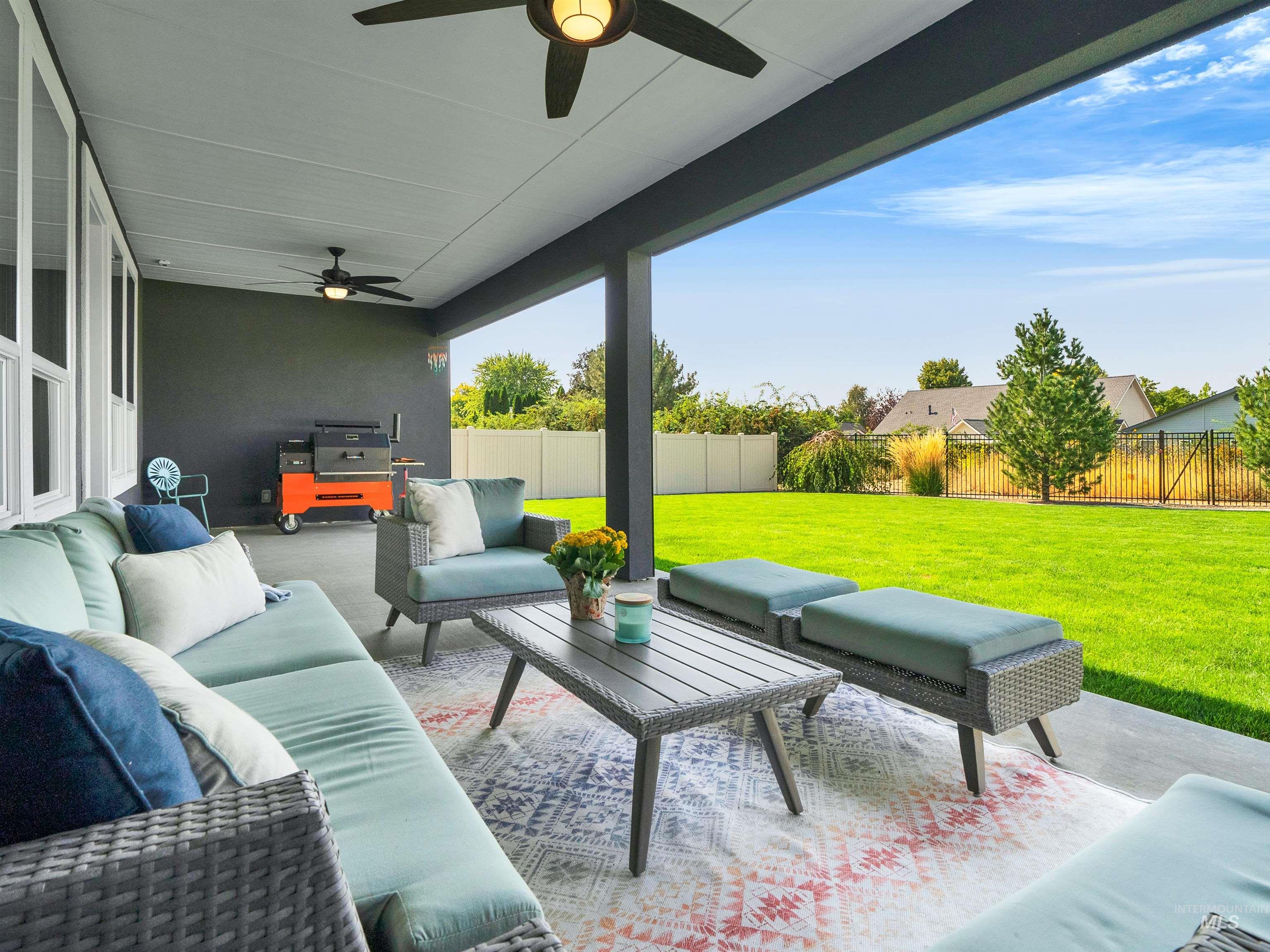Fenced backyard featuring an outdoor hangout area, a patio area, a ceiling fan, and area for grilling