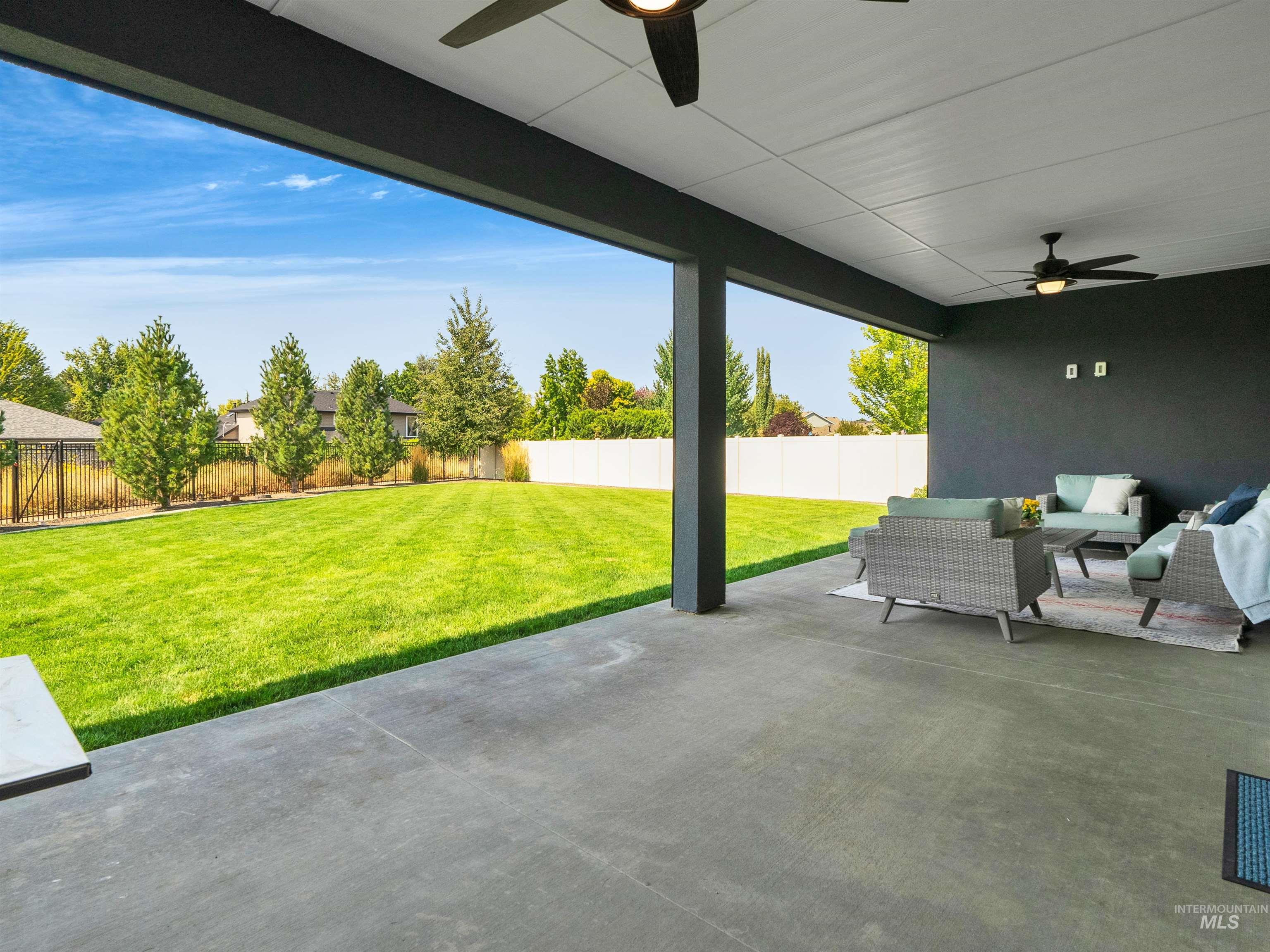 Fenced backyard with a ceiling fan, a patio area, and outdoor lounge area