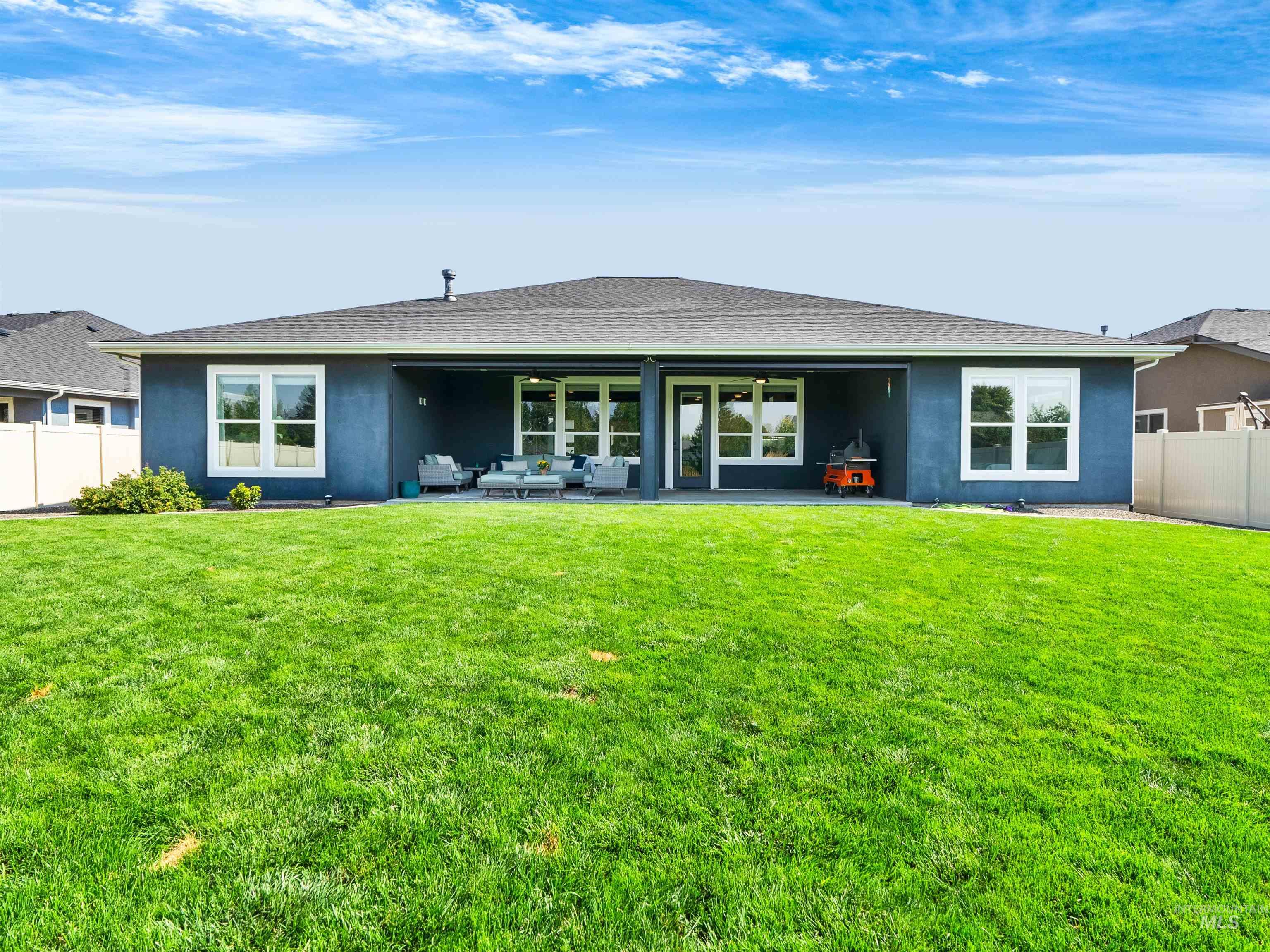 Back of property with a fenced backyard, a patio area, stucco siding, and an outdoor hangout area