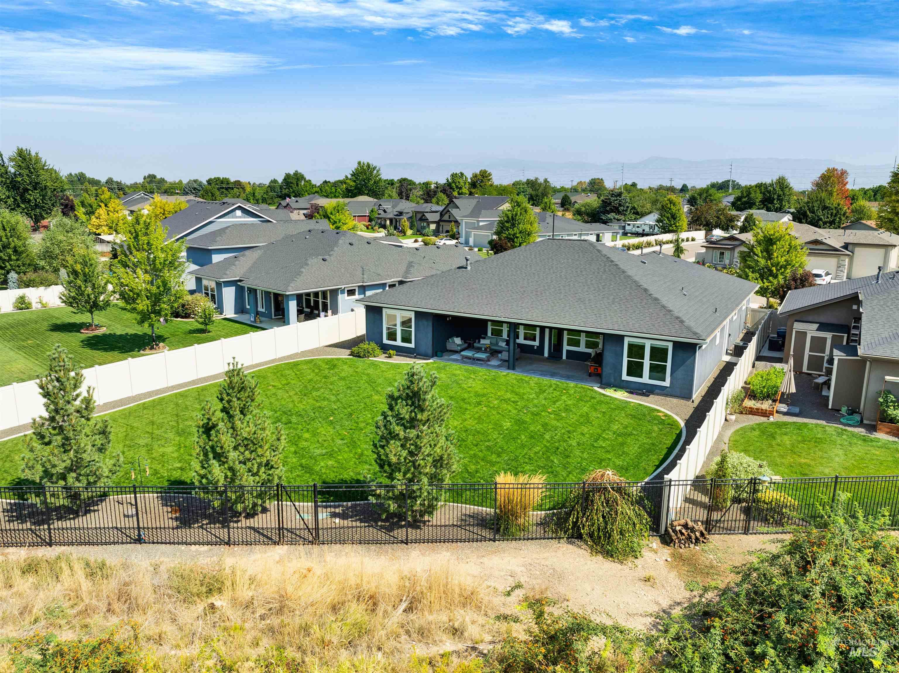 Rear view of property featuring a patio area, a residential view, a fenced backyard, and a shingled roof