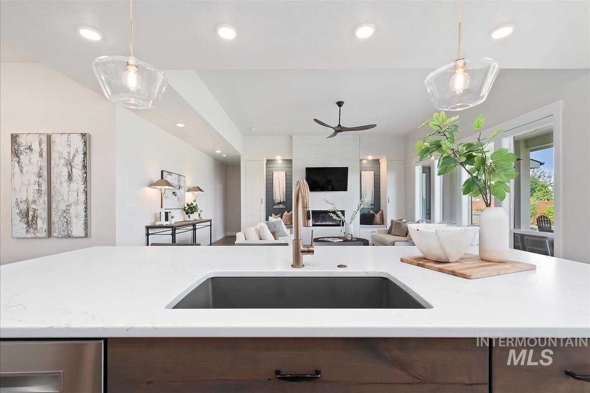 Kitchen featuring ceiling fan, light stone countertops, open floor plan, recessed lighting, and modern cabinets