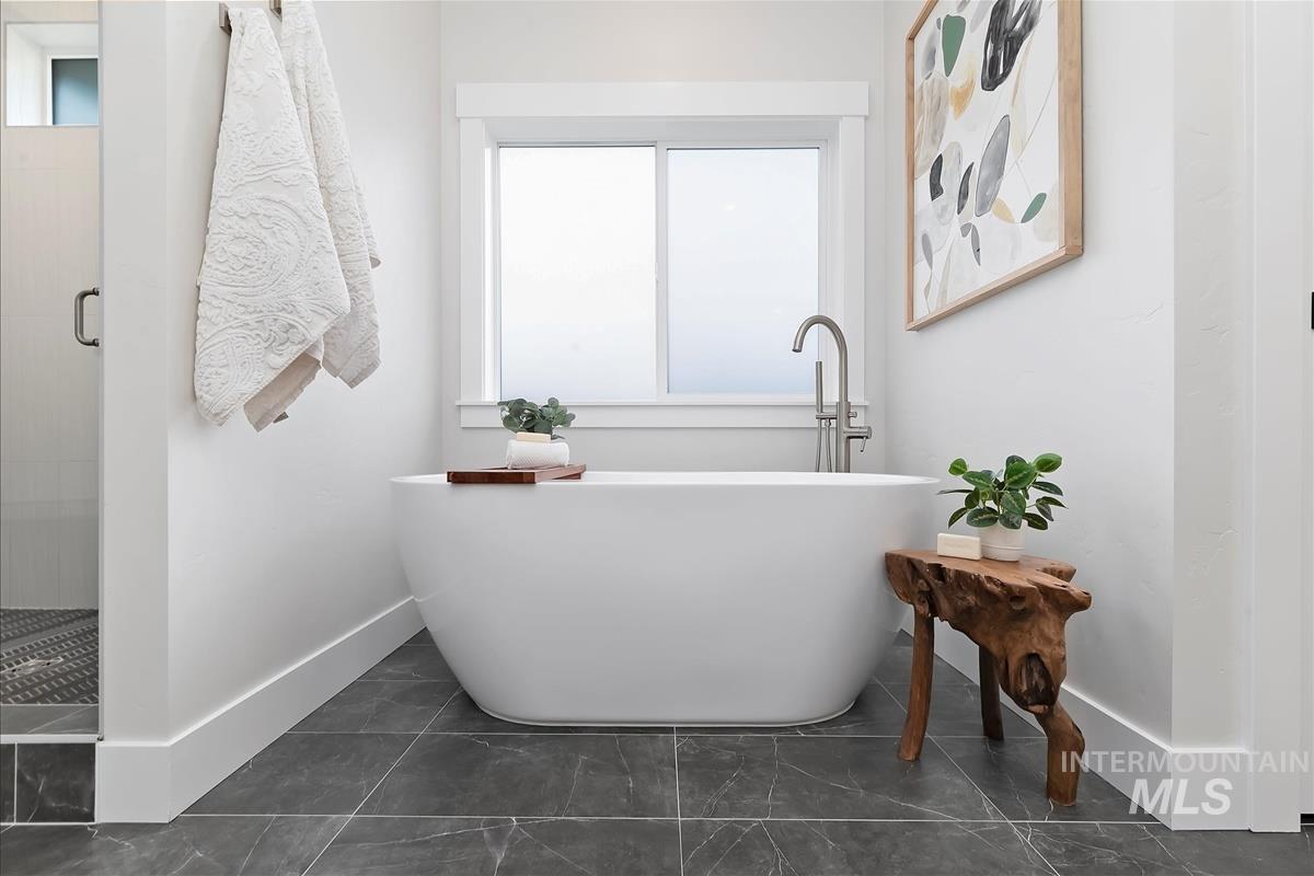 Bathroom with a shower stall and a freestanding tub