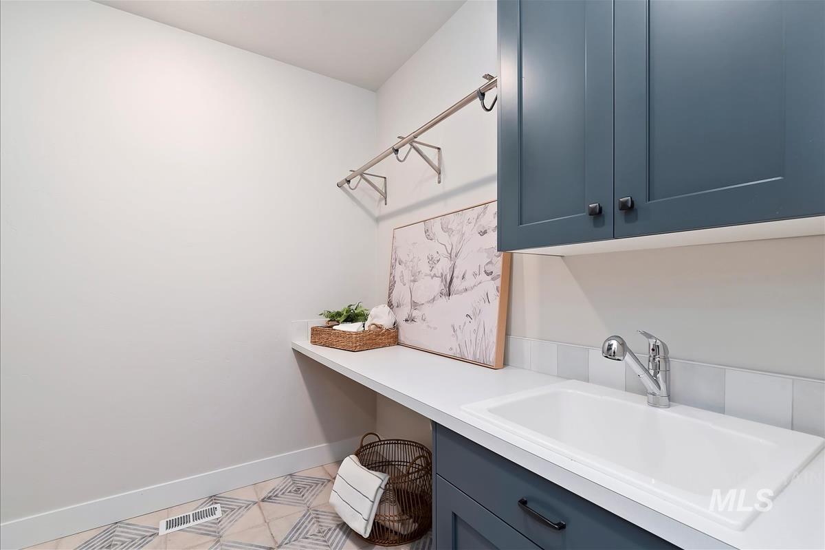 Laundry room featuring a sink and baseboards