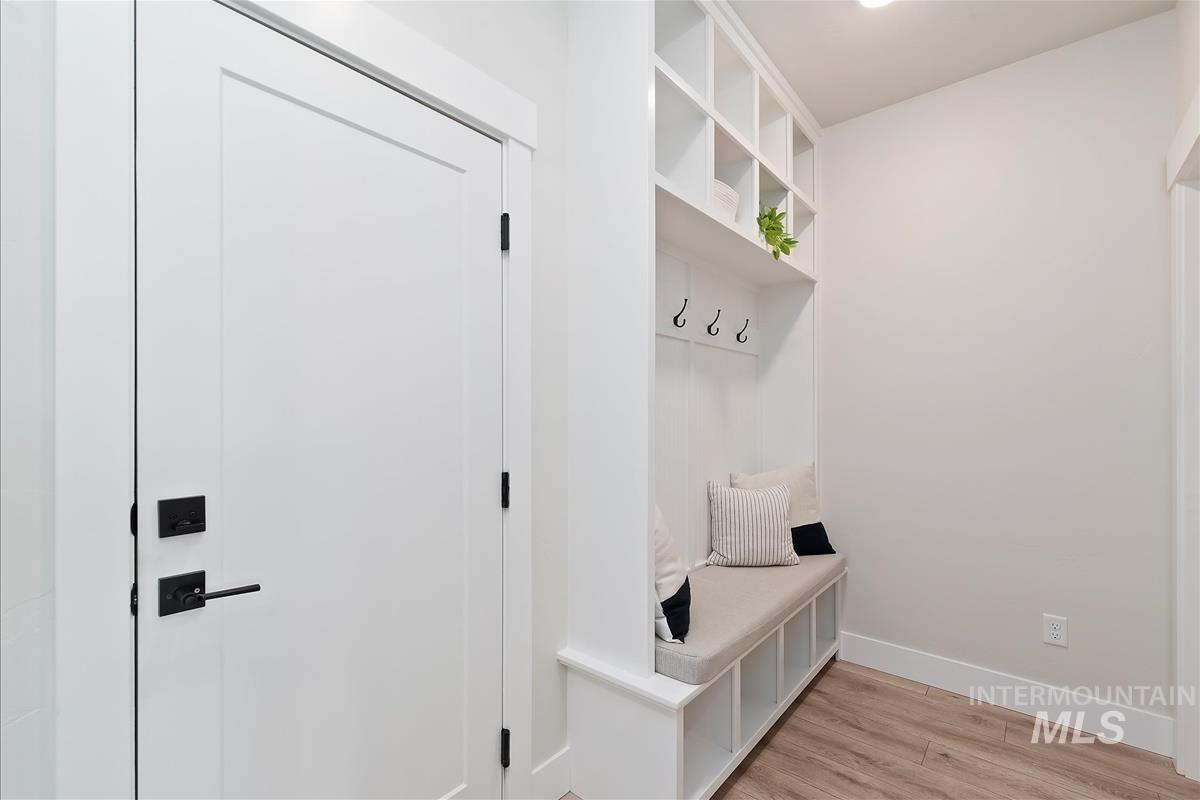 Mudroom featuring light wood finished floors and baseboards