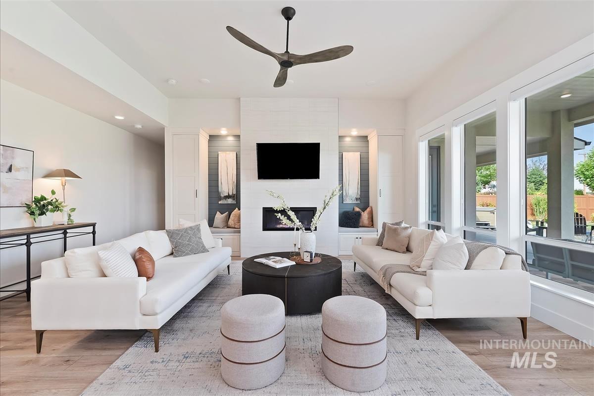 Living area with light wood-style floors, a ceiling fan, and recessed lighting