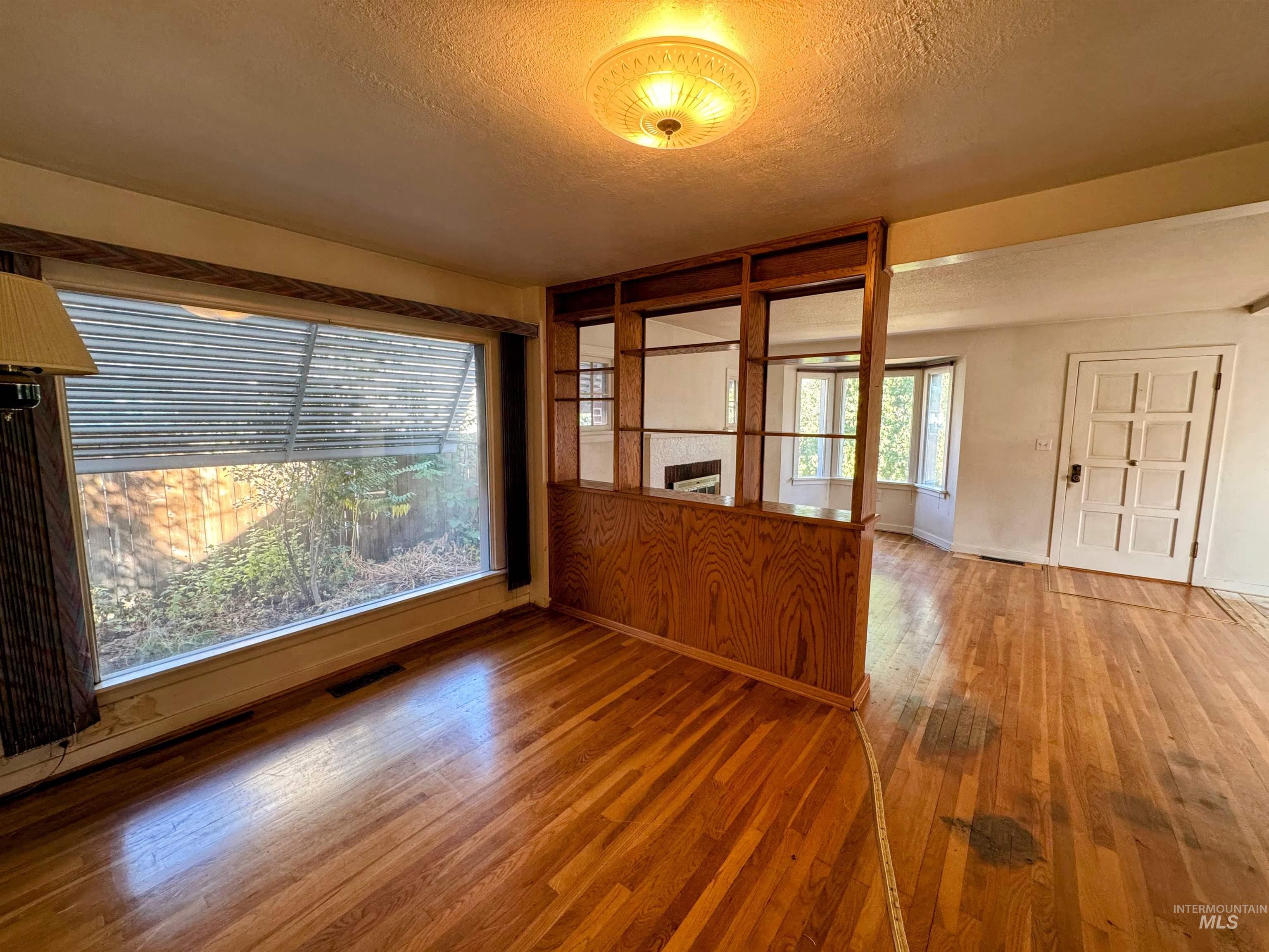 Spare room featuring hardwood / wood-style flooring and a textured ceiling