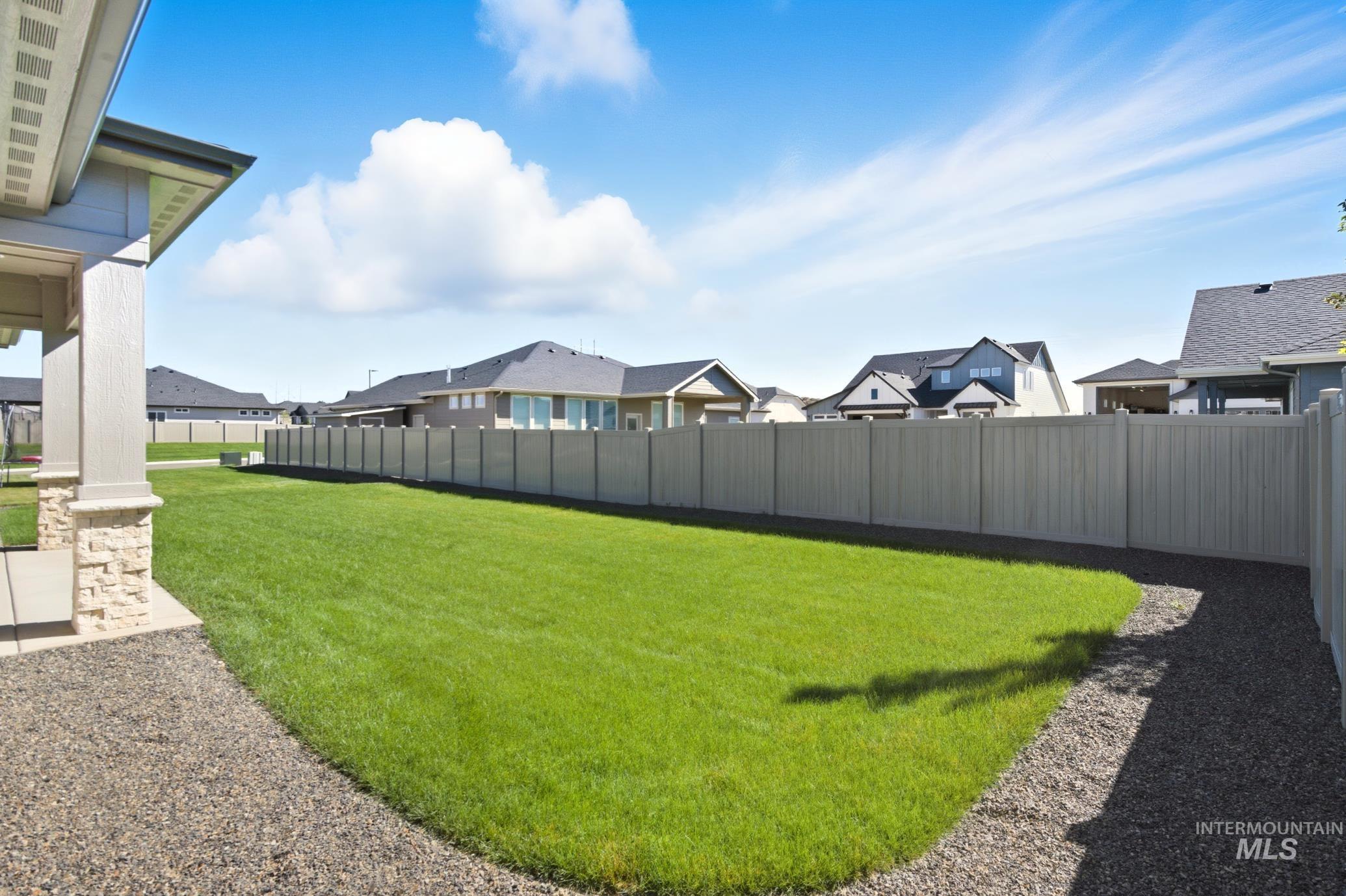 Fenced backyard featuring a residential view and a patio area