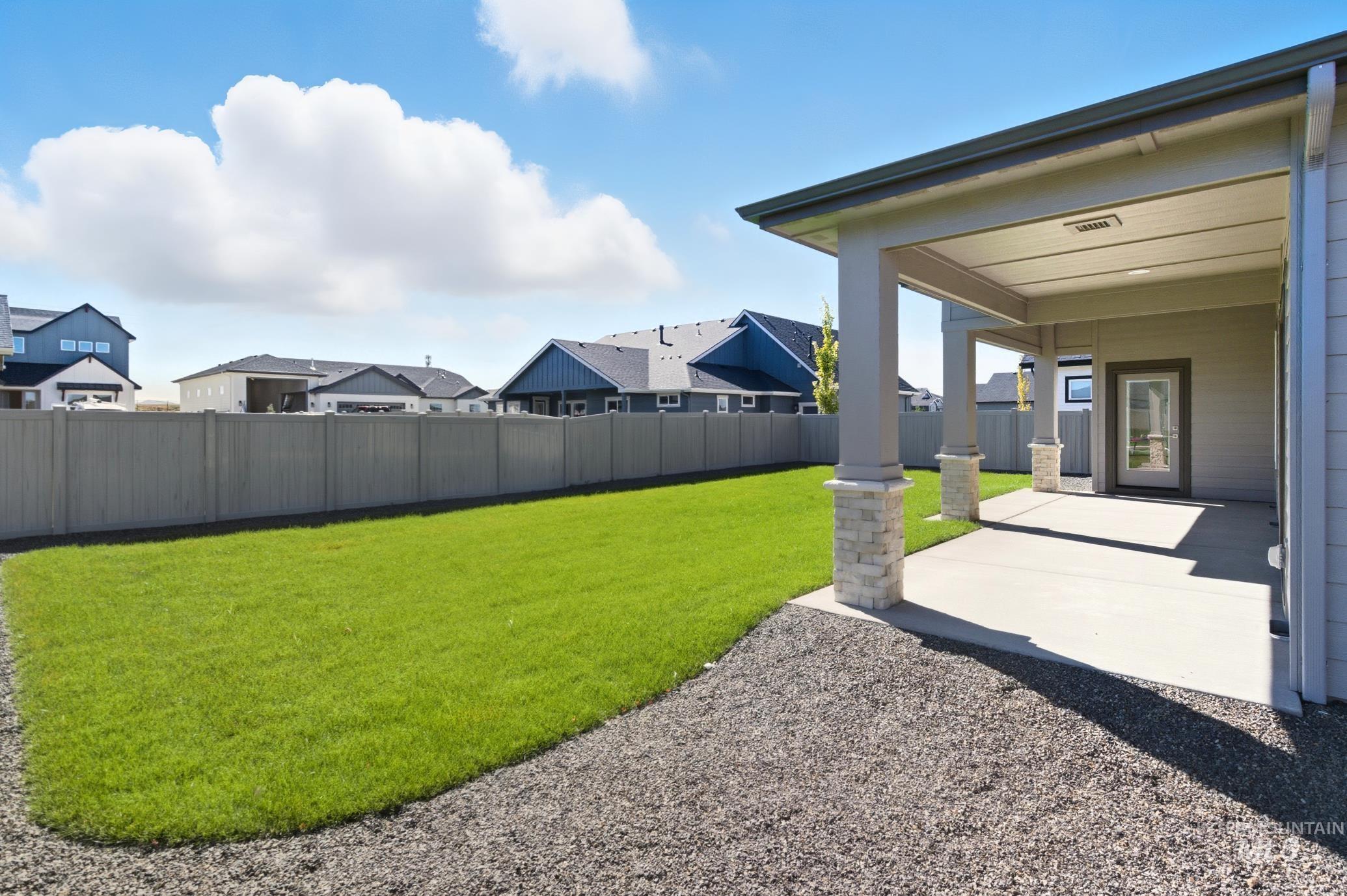 Fenced backyard with a patio area and a residential view