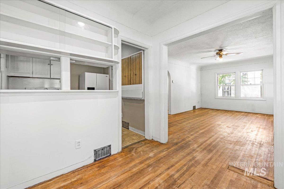 Unfurnished living room featuring hardwood / wood-style floors, a textured ceiling, and a ceiling fan
