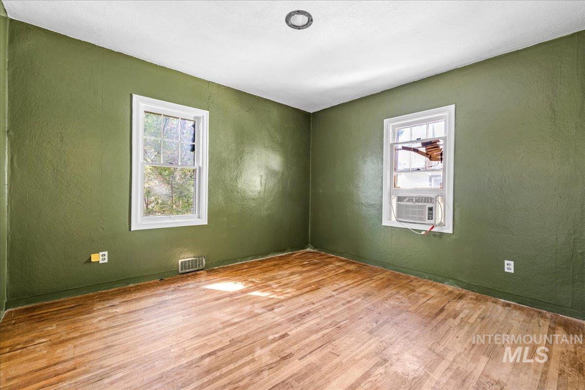 Spare room with a textured wall and wood finished floors