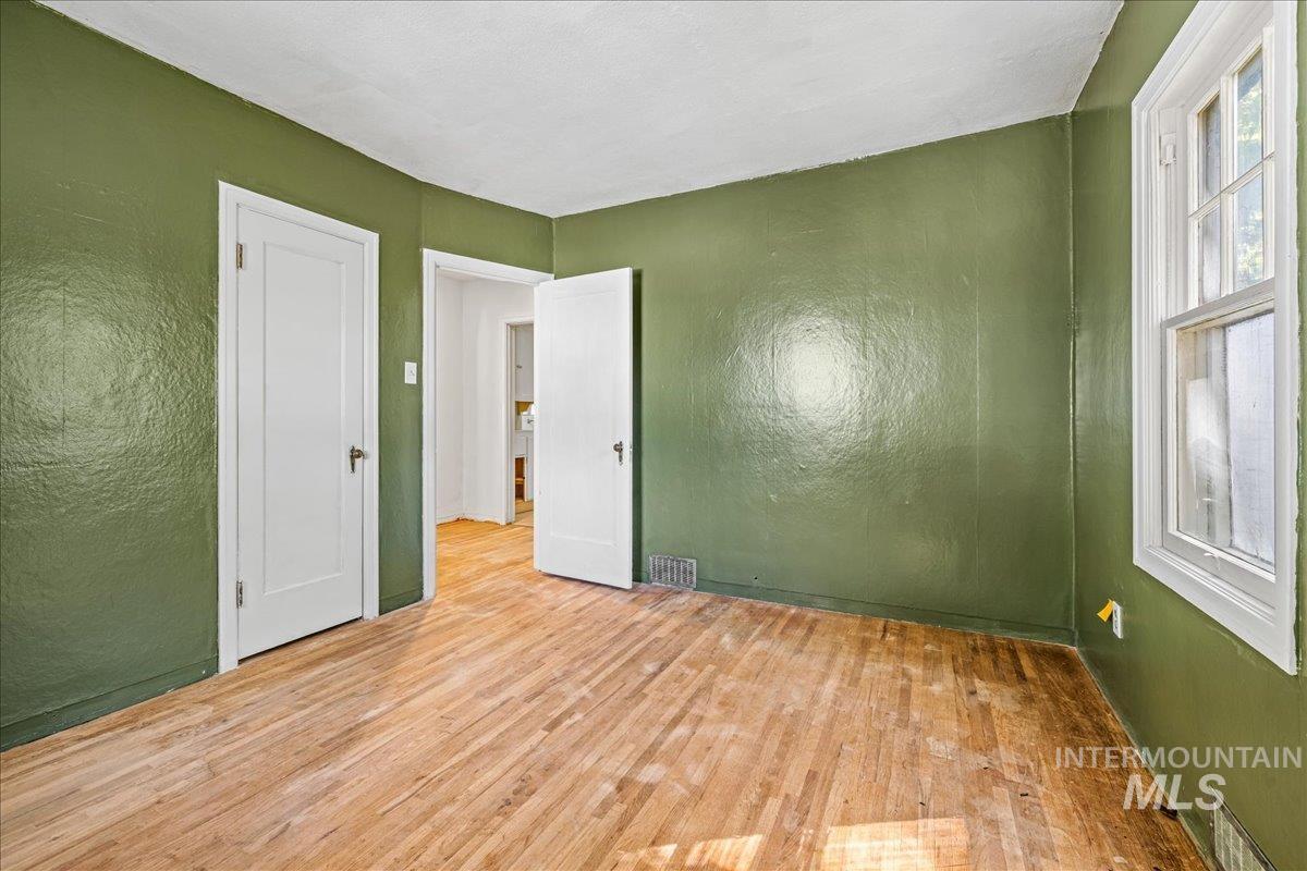 Unfurnished bedroom featuring a textured wall and wood finished floors