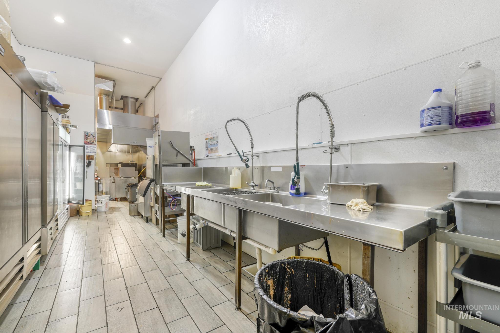 Kitchen with stainless steel counters, wood tiled floors, and high end refrigerator