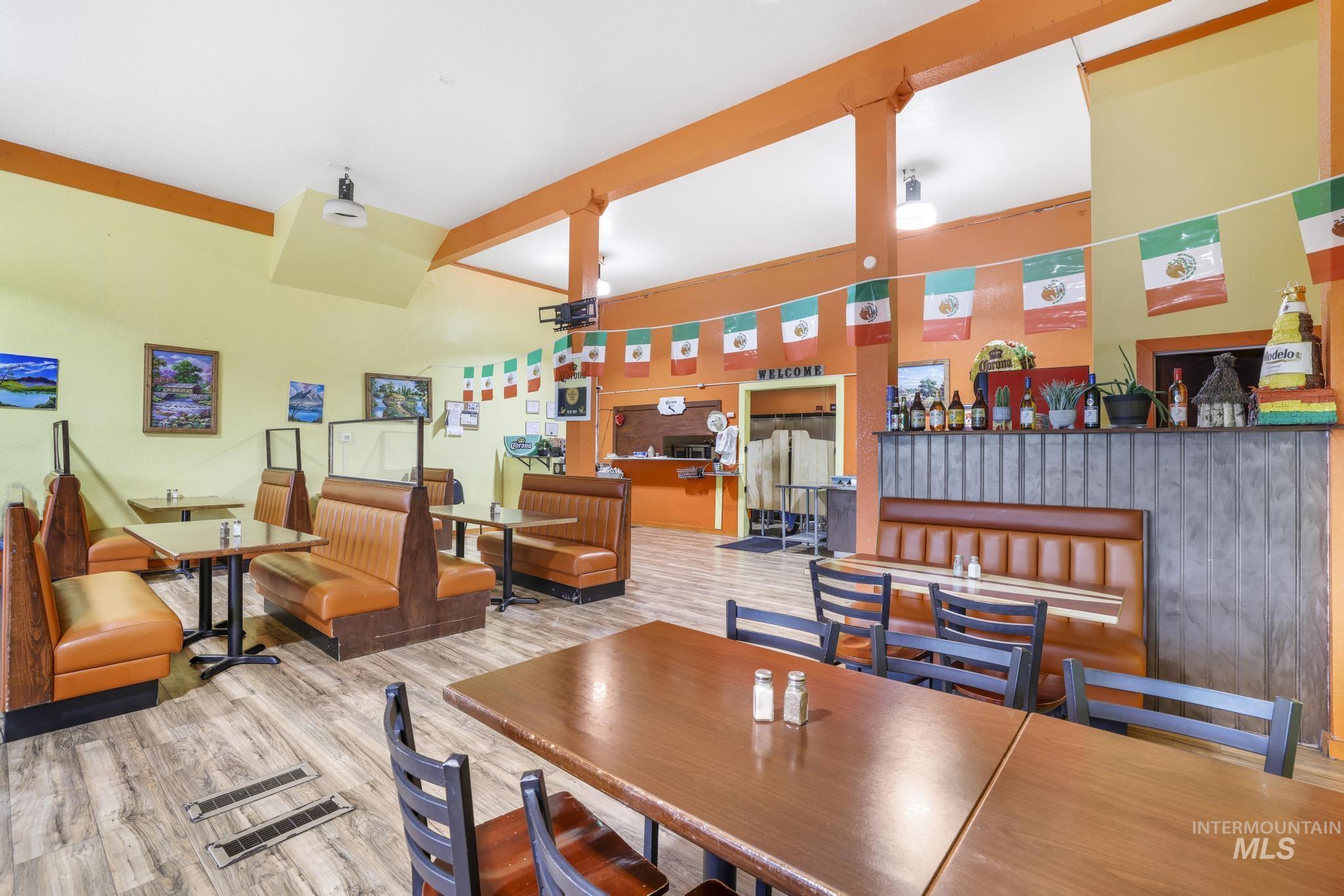 Dining area with beam ceiling and wood finished floors