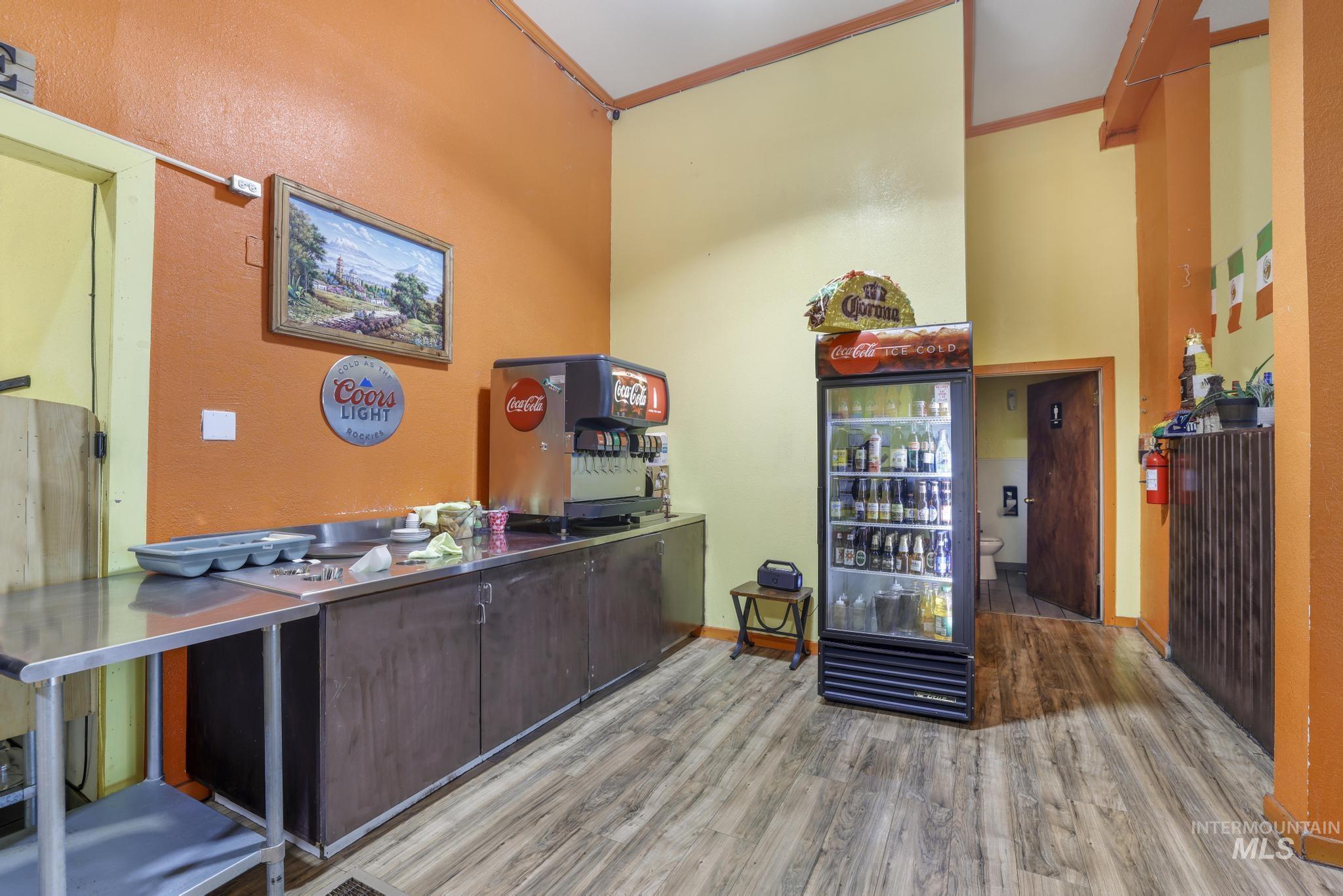 Home office featuring light wood-style floors, ornamental molding, and a towering ceiling