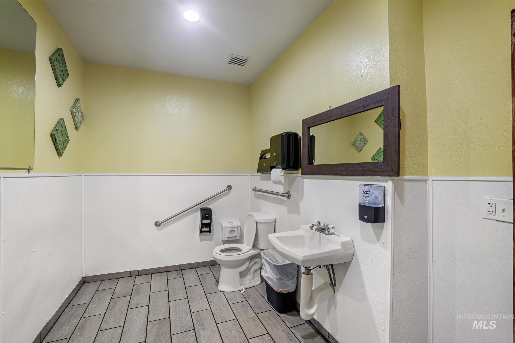 Half bathroom with toilet and wood tiled floors