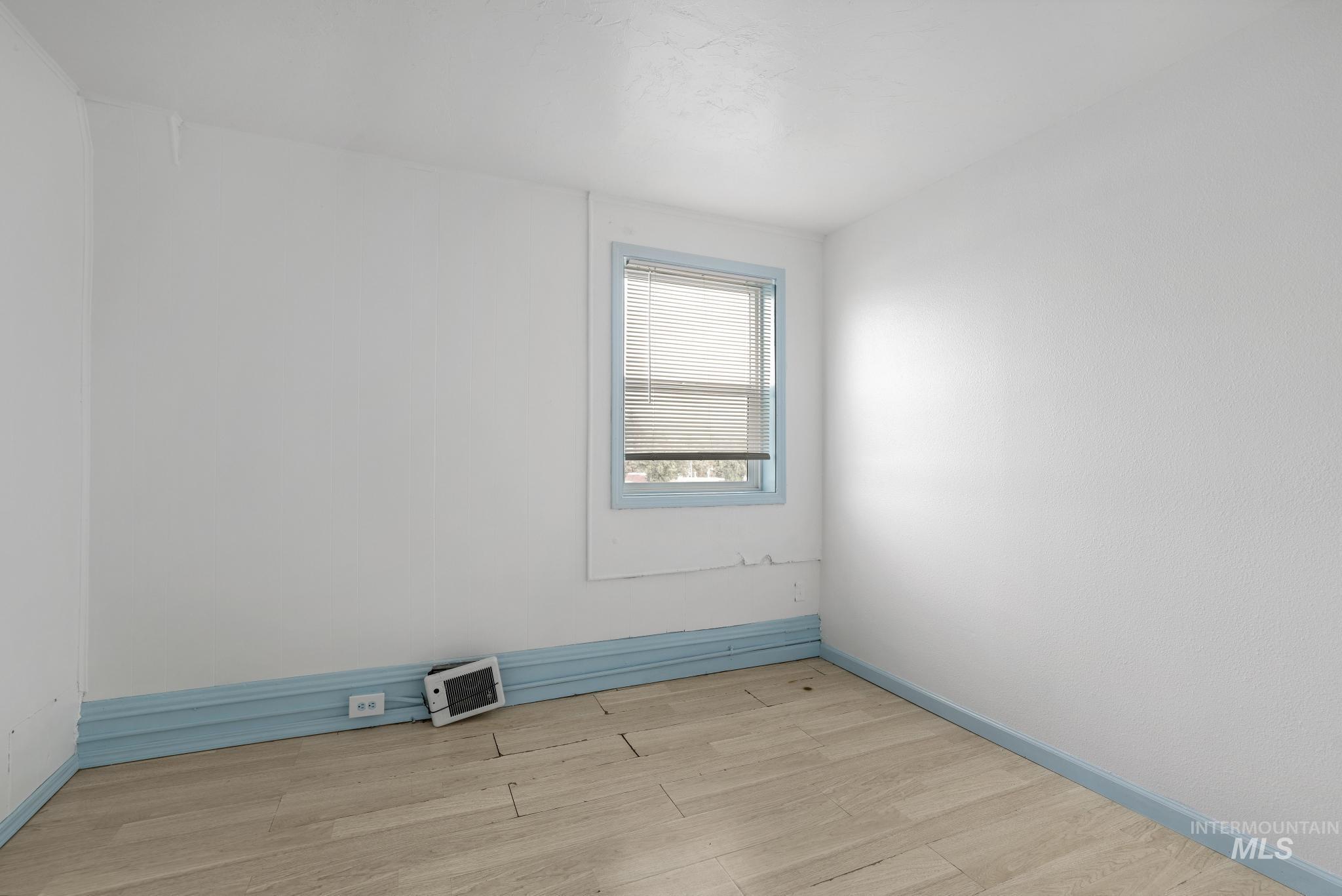 Unfurnished room featuring light wood-style floors and baseboards