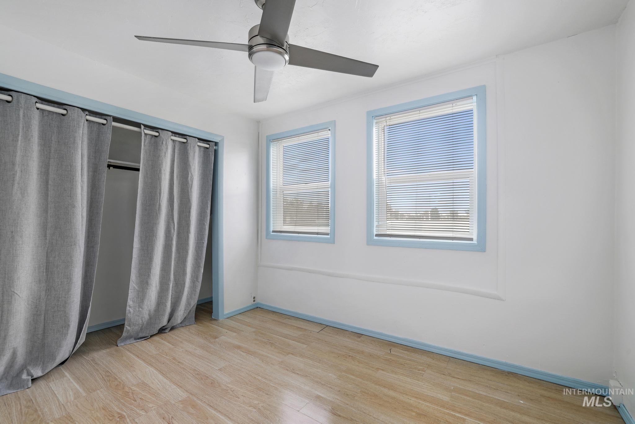 Unfurnished bedroom featuring light wood finished floors, ceiling fan, and a closet