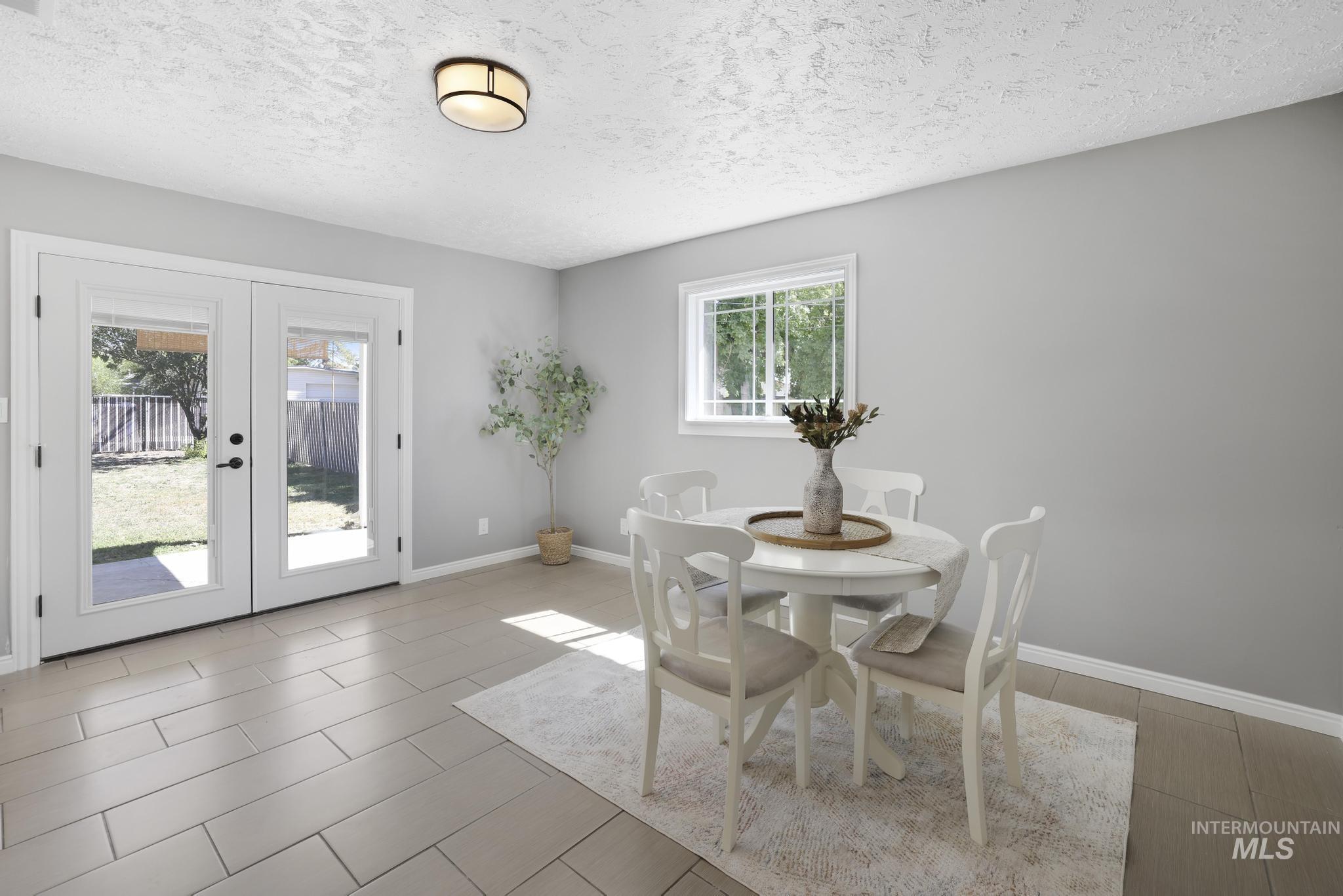 Dining area featuring french doors and a textured ceiling