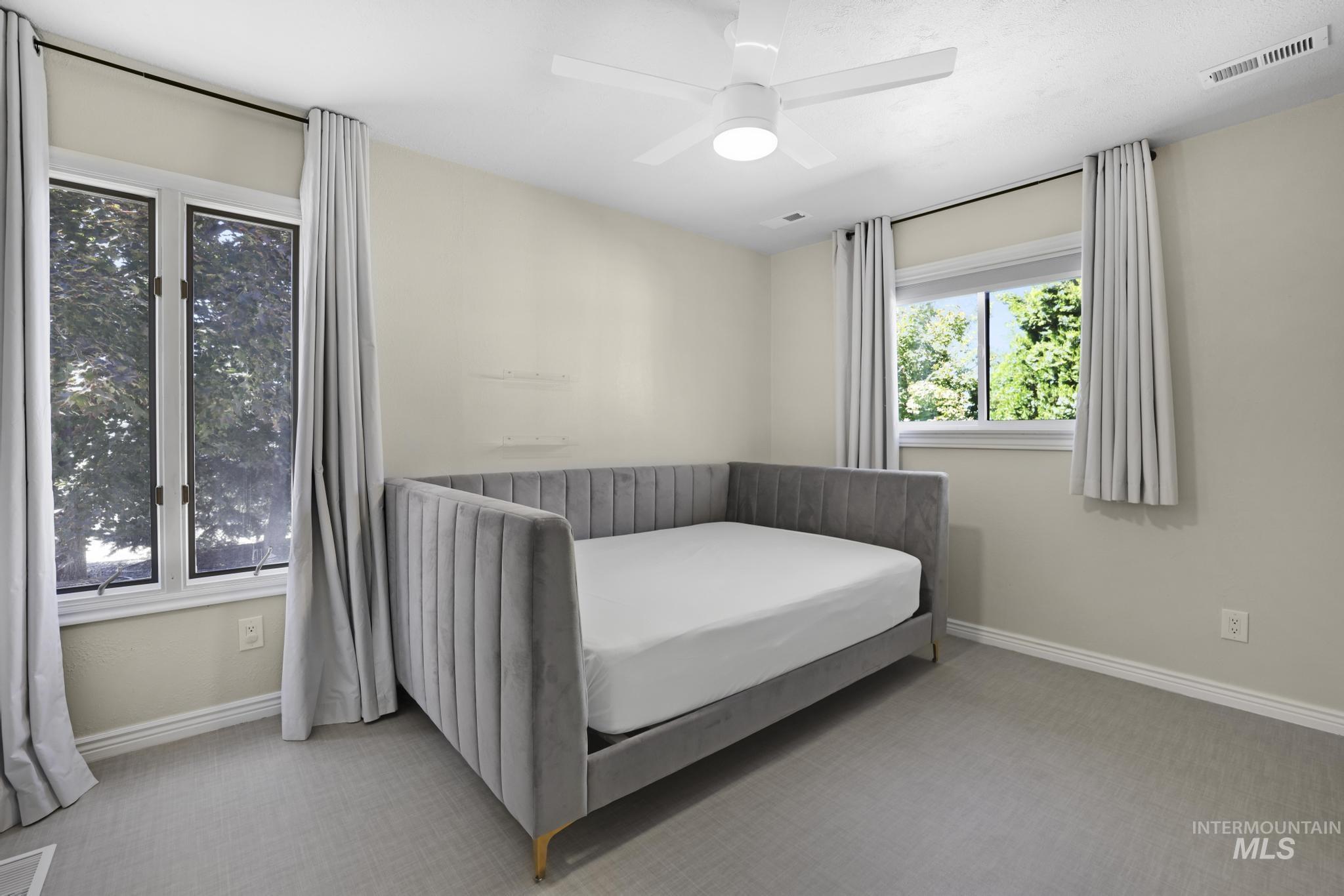 Carpeted bedroom featuring baseboards and ceiling fan