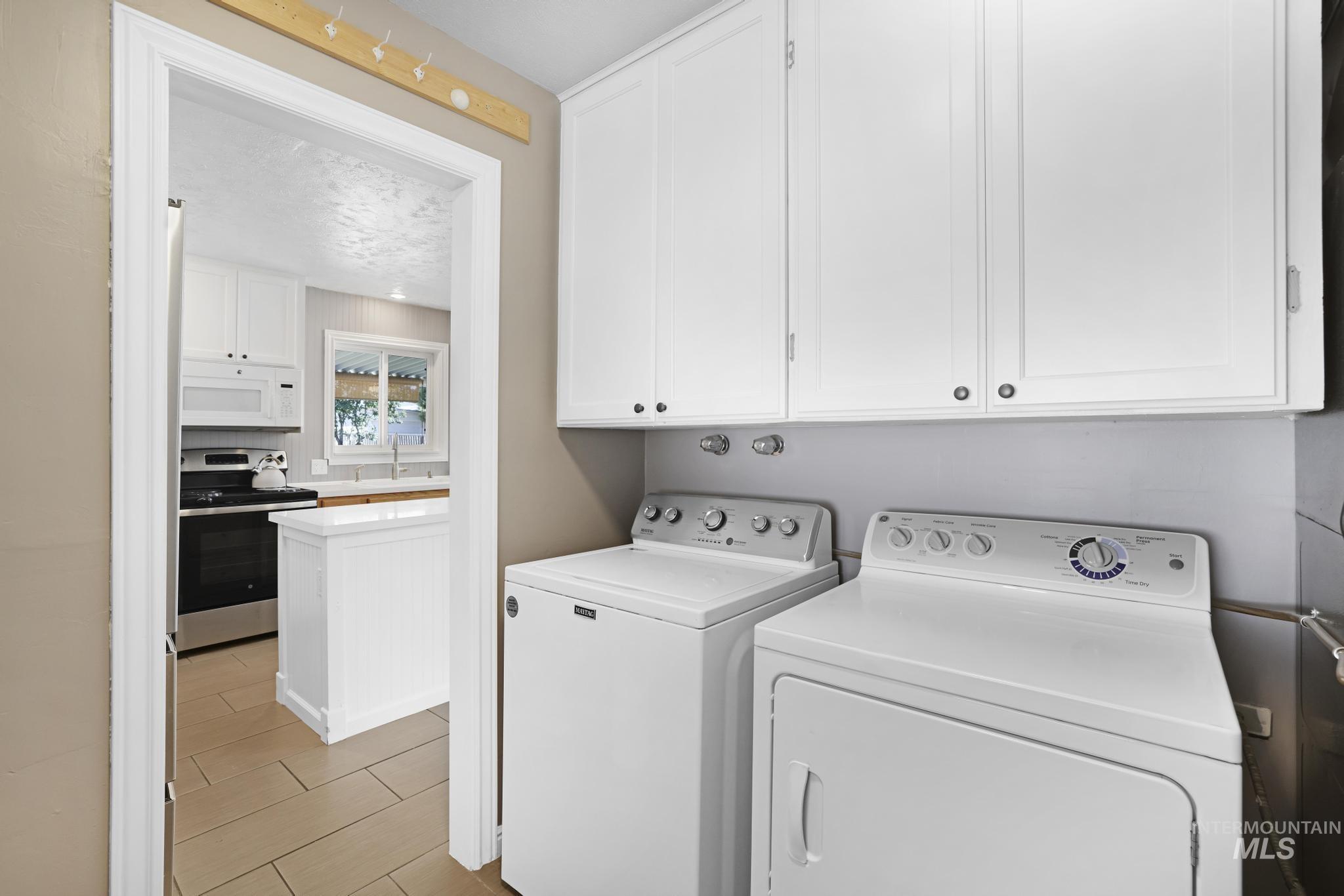Laundry room with washing machine and clothes dryer and cabinet space