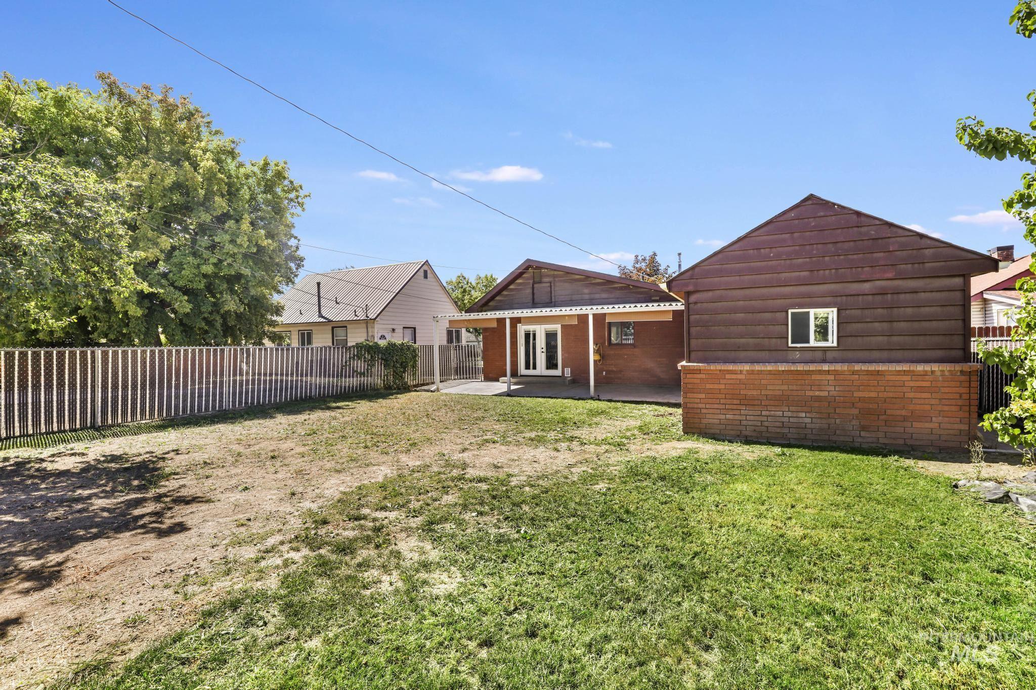 Rear view of house featuring a fenced backyard and a patio