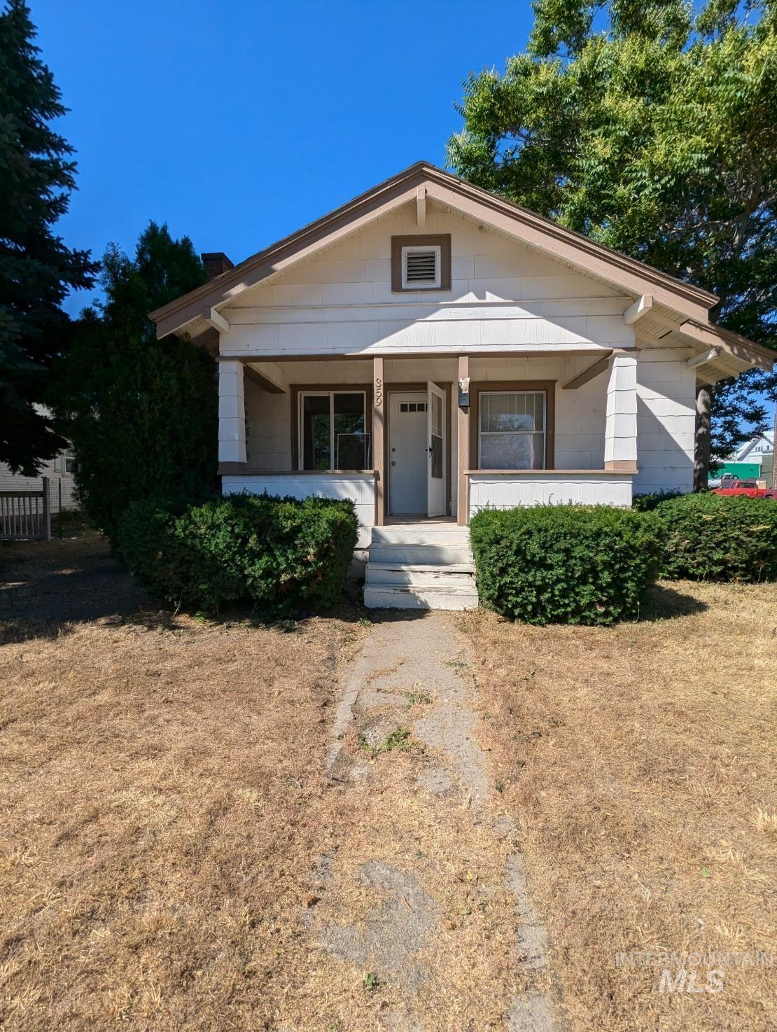 Bungalow with covered porch and a front yard
